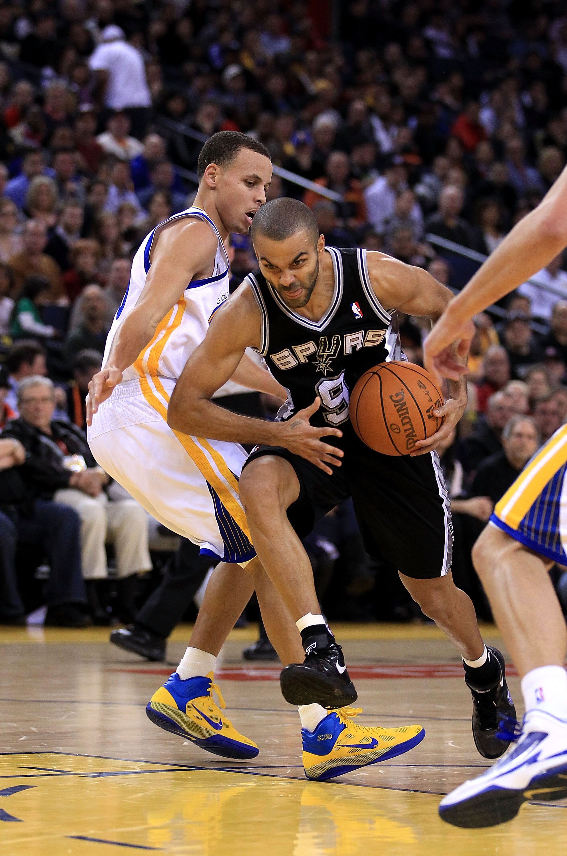 OAKLAND, CA - JANUARY 24:  Tony Parker #9 of the San Antonio Spurs drives on Stephen Curry of the Golden State Warriors at Oracle Arena on January 24, 2011 in Oakland, California.  NOTE TO USER: User expressly acknowledges and agrees that, by downloading