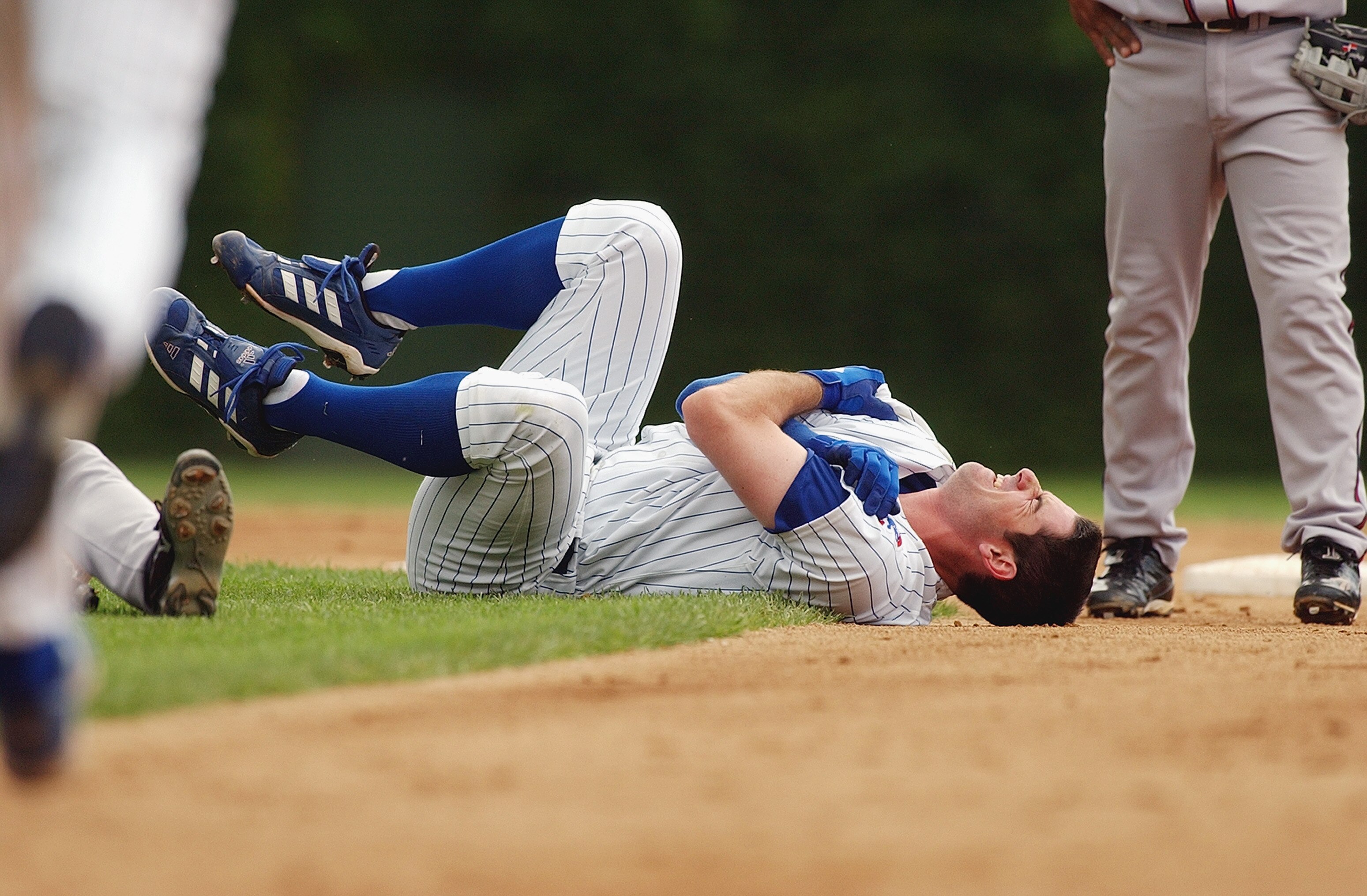 CHICAGO - JULY 11:  Starting pitcher Mark Prior #22 of the Chicago Cubs grabs his shoulder in pain after colliding with second baseman Marcus Giles #22 of the Atlanta Braves during the second inning of the game at Wrigley Field on July 11, 2003 in Chicago
