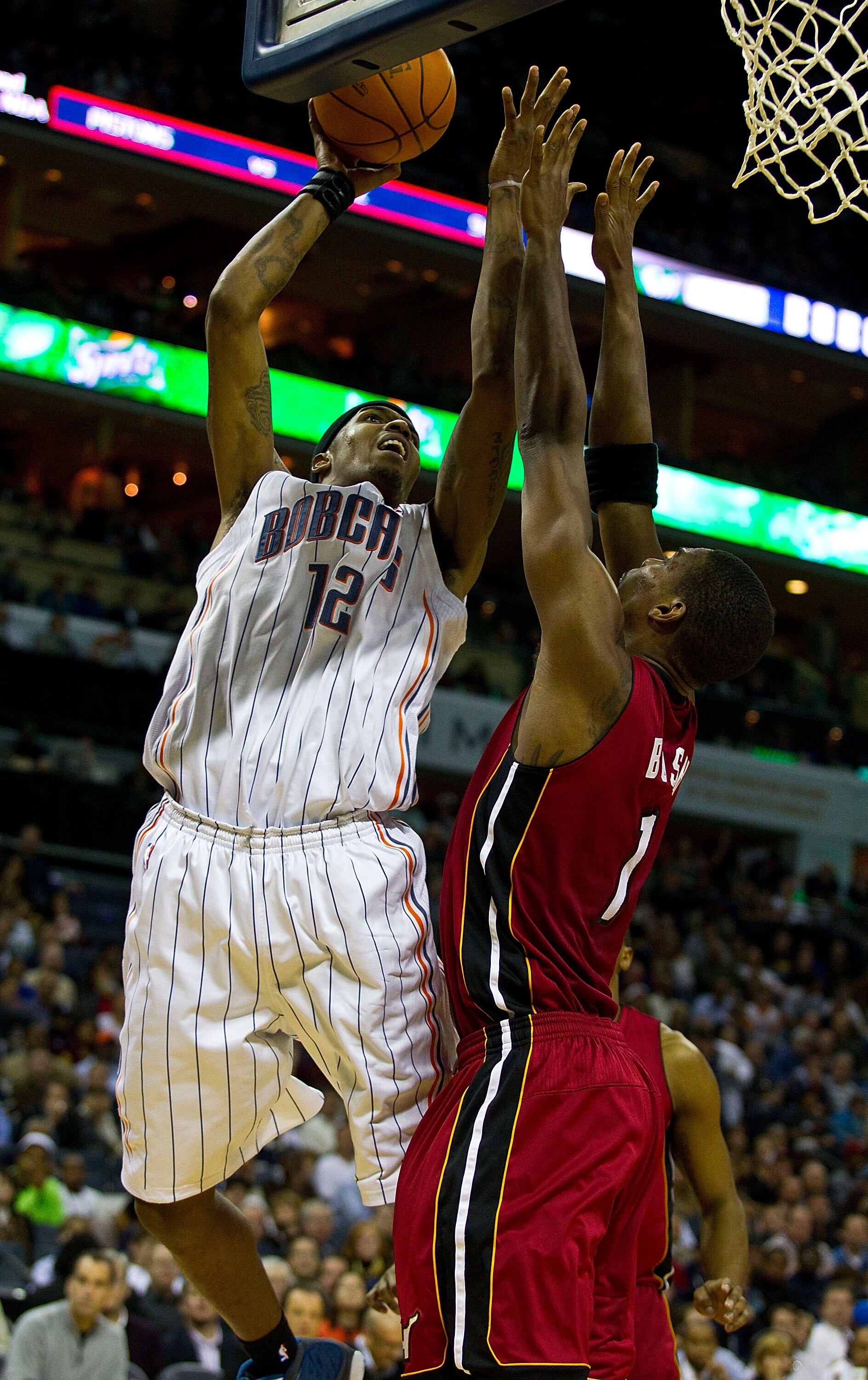 CHARLOTTE, NC - JANUARY 03: Tyrus Thomas #12 of the Charlotte Bobcats shoots over Chris Bosh of the Miami Heat at Time Warner Cable Arena on January 3, 2011 in Charlotte, North Carolina.  The Heat defeated the Bobcats 96-82.  (Photo by Brian A. Westerholt