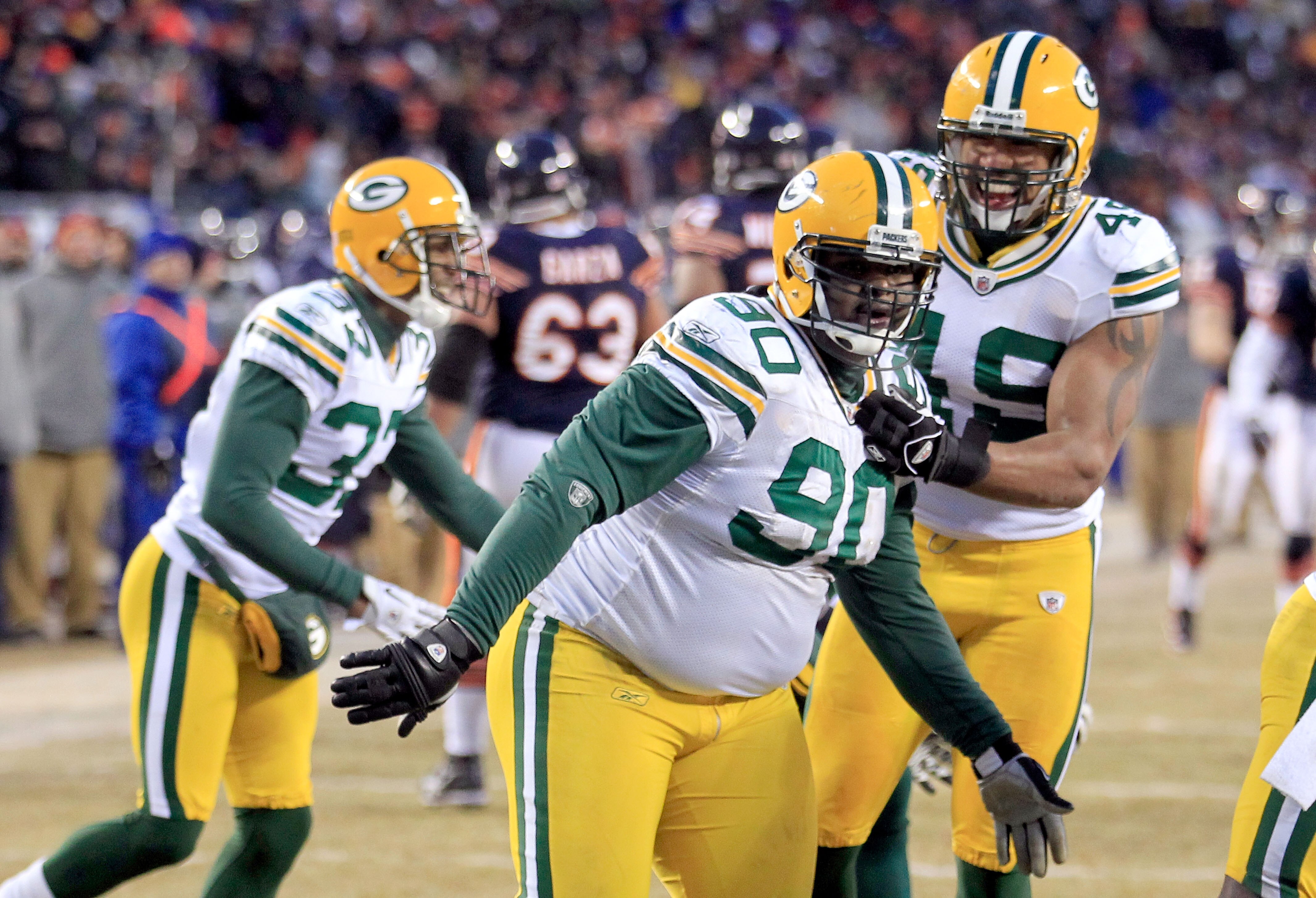 CHICAGO, IL - JANUARY 23:  B.J. Raji #90 of the Green Bay Packers reacts with teammates after scoring on a 18-yard interception return for a touchdown in the fourth quarter against the Chicago Bears in the NFC Championship Game at Soldier Field on January
