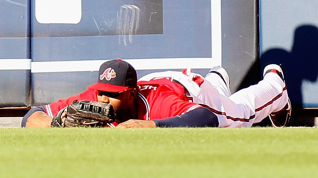 ATLANTA - OCTOBER 10:  Jason Heyward #22 of the Atlanta Braves lays on the ground after colliding with the wall misplaying a fly ball hit by Mike Fontenot #14 of the San Francisco Giants during Game Three of the NLDS of the 2010 MLB Playoffs at Turner Fie