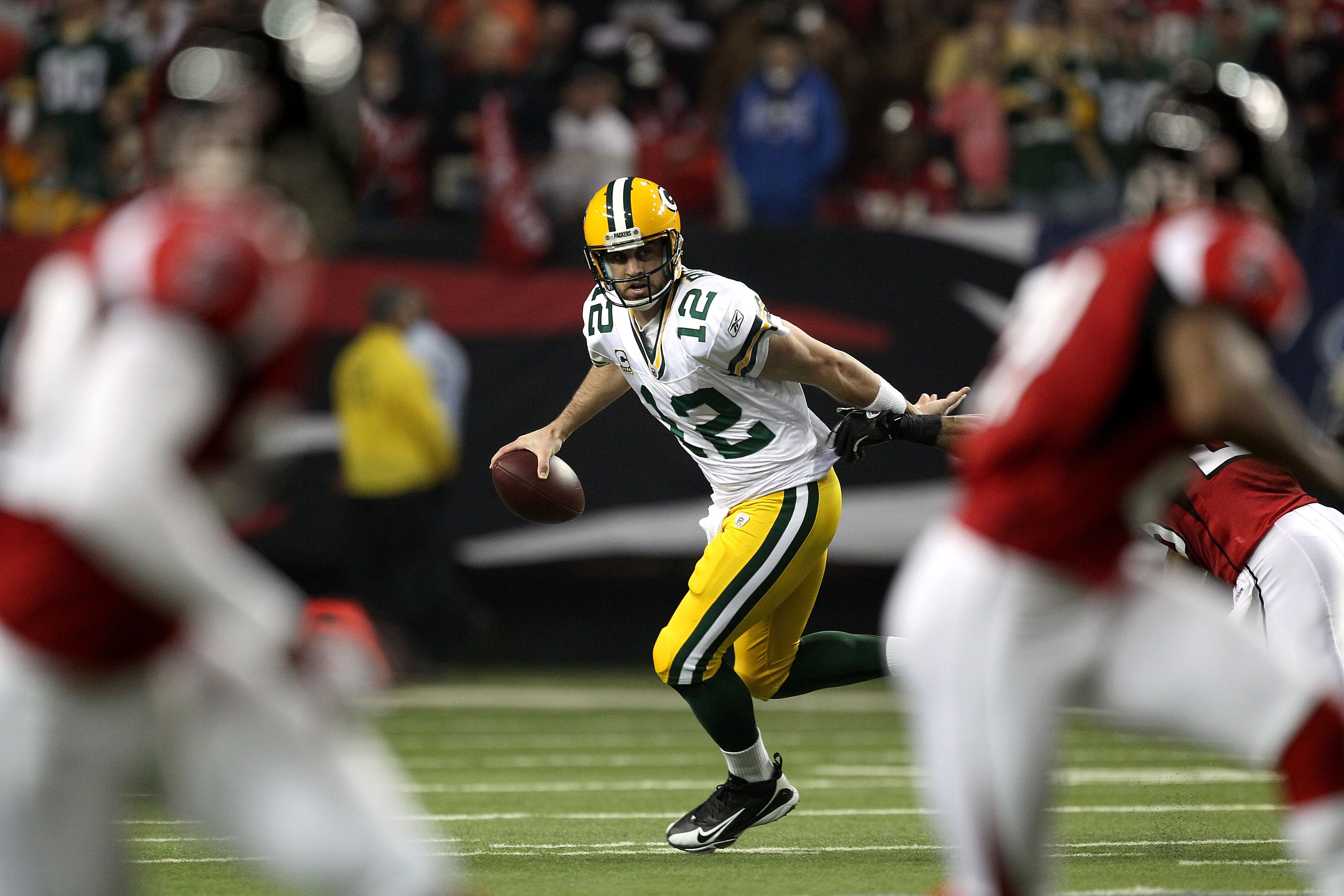 ATLANTA, GA - JANUARY 15:  Aaron Rodgers #12 of the Green Bay Packers rolls out of the pocket to pass against the Atlanta Falcons during their 2011 NFC divisional playoff game at Georgia Dome on January 15, 2011 in Atlanta, Georgia.  (Photo by Streeter Le