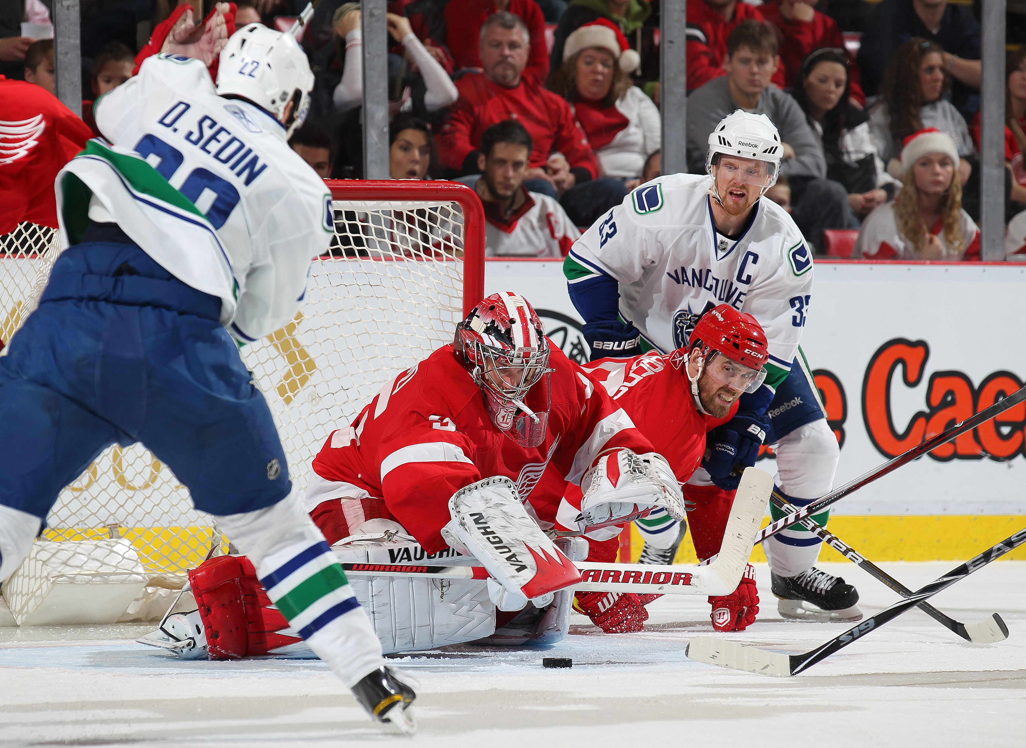 DETROIT, MI - DECEMBER 22: Henrik Sedin #33 and Daniel Sedin #22 of the Vancouver Canucks press for a goal against Henrik Zetterberg #40 and Jimmy Howard #35 of the Detroit Red Wings in a game on December 22, 2010 at the Joe Louis Arena in Detroit, Michi DETROIT, MI - DECEMBER 22: Henrik Sedin #33 and Daniel Sedin #22 of the Vancouver Canucks press for a goal against Henrik Zetterberg #40 and Jimmy Howard #35 of the Detroit Red Wings in a game on December 22, 2010 at the Joe Louis Arena in Detroit, Michi