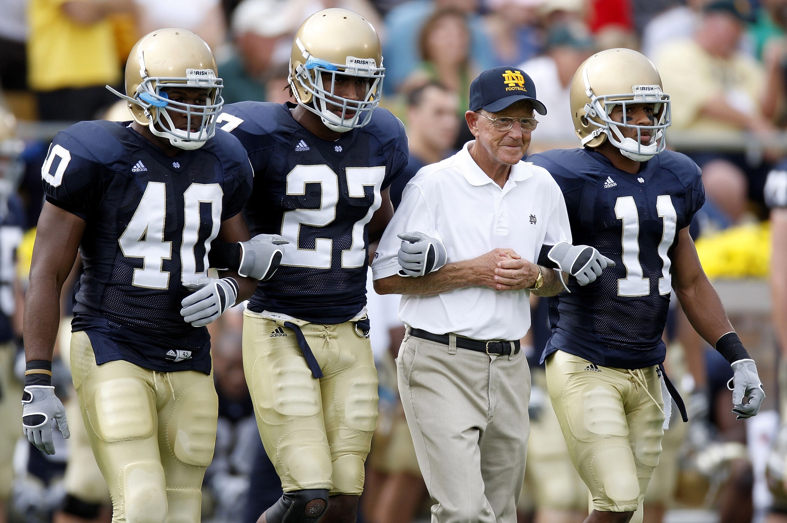SOUTH BEND, IN - SEPTEMBER 13:  Former head coach Lou Holtz of the Notre Dame Fighting Irish walks out for the coin toss with David Grimes #11, David Bruton #27 and Maurice Crum #40 prior to playing the Michigan Wolverines on September 13, 2008 at Notre D