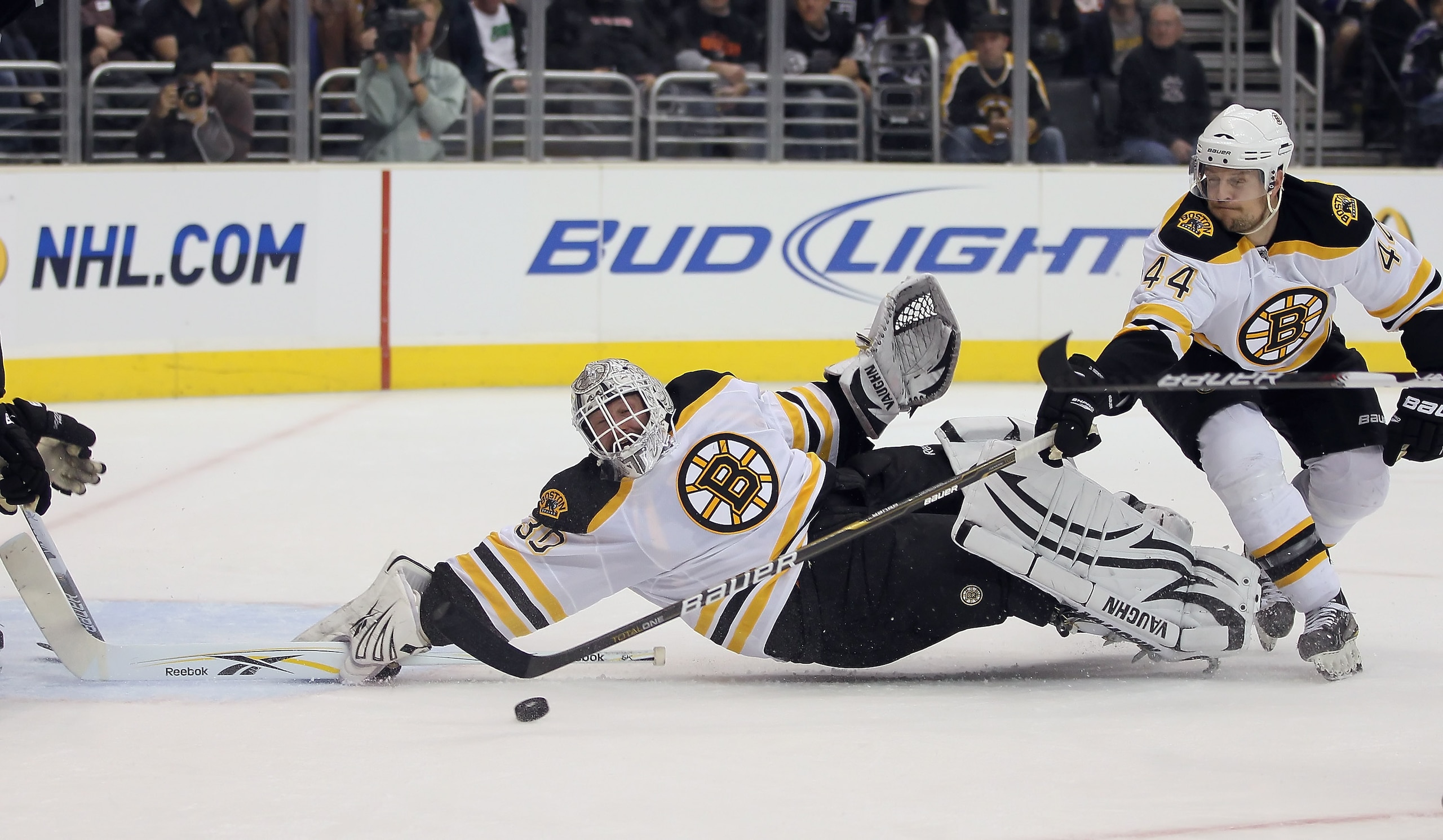 LOS ANGELES, CA - JANUARY 24:  Goaltender Tim Thomas #30 of the Boston Bruins lunges for the puck as teammate Dennis Seidenberg #44 defends against the Los Angeles Kings in the second period at Staples Center on January 24, 2011 in Los Angeles, California