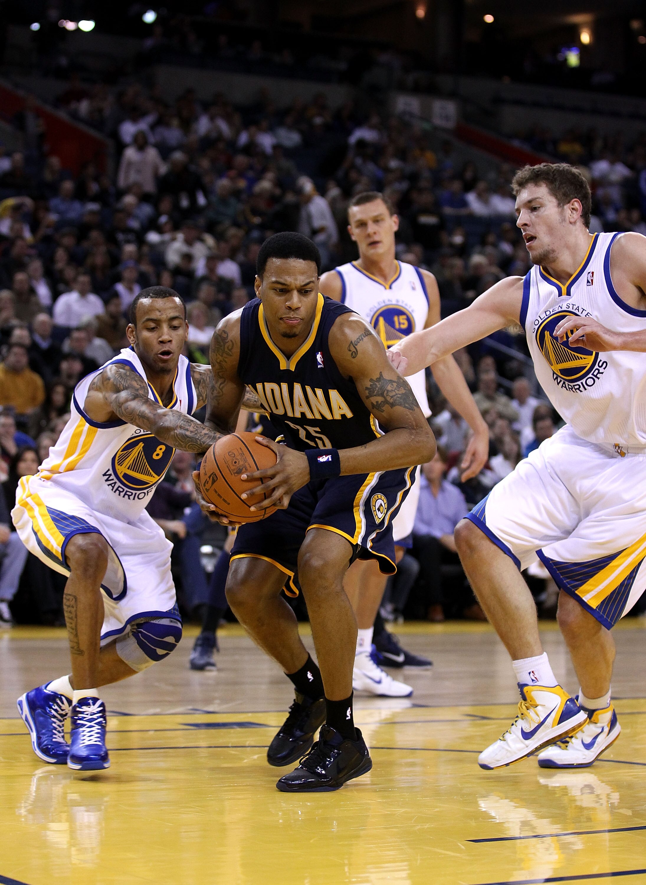 OAKLAND, CA - JANUARY 19:  Brandon Rush #25 of the Indiana Pacers  tries to keep the ball from Monta Ellis #8 and David Lee #8 of the Golden State Warriors at Oracle Arena on January 19, 2011 in Oakland, California.  NOTE TO USER: User expressly acknowled
