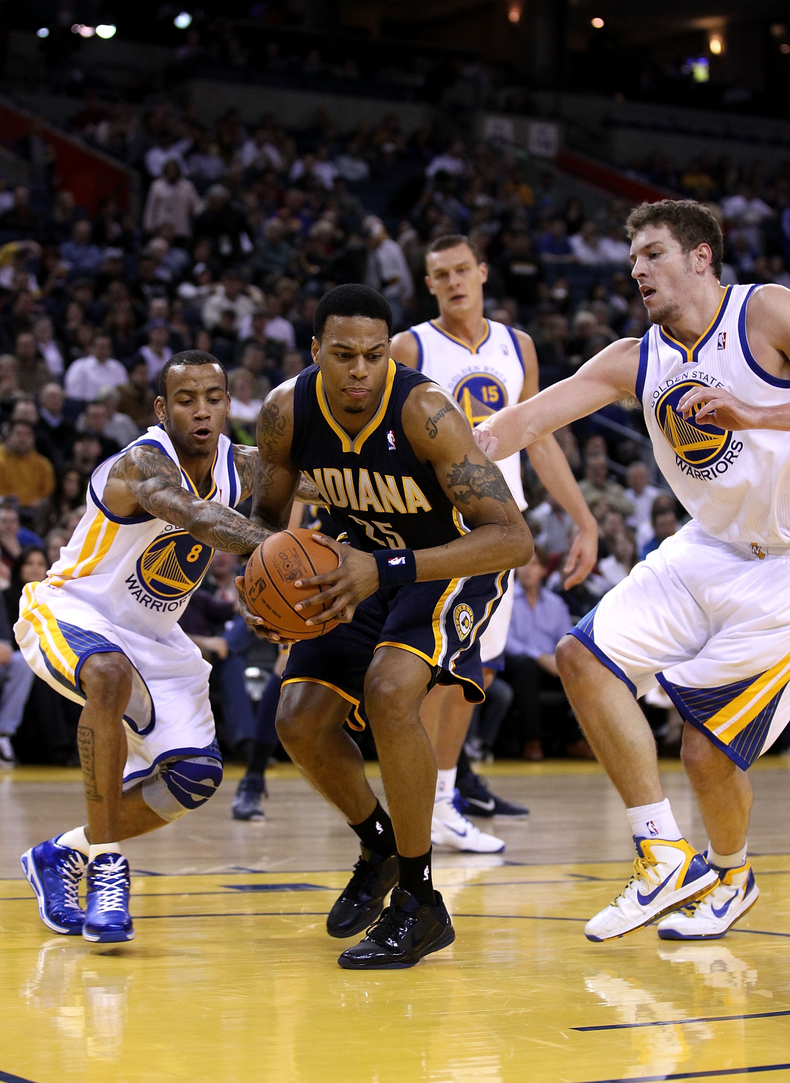 OAKLAND, CA - JANUARY 19:  Brandon Rush #25 of the Indiana Pacers  tries to keep the ball from Monta Ellis #8 and David Lee #8 of the Golden State Warriors at Oracle Arena on January 19, 2011 in Oakland, California.  NOTE TO USER: User expressly acknowled