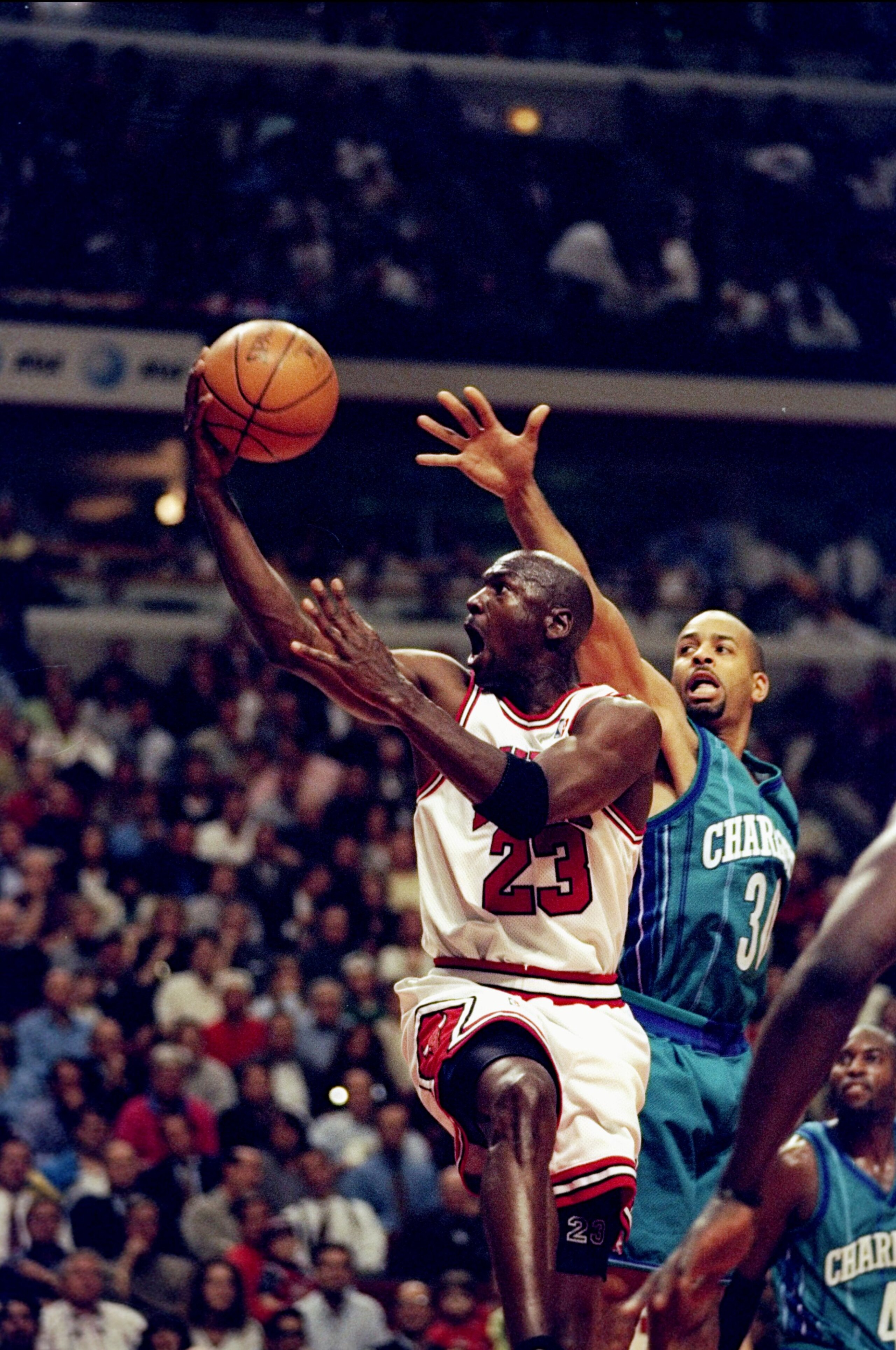 13 May 1998: Michael Jordan #23 of the  Chicago Bulls makes a lay-up as Dell Curry #30 of the Charlotte Hornets tries to block at the United Center in Chicago, Illinios. The Bulls defeated the Hornets 93-84. Mandatory Credit: Jonathan Daniel  /Allsport