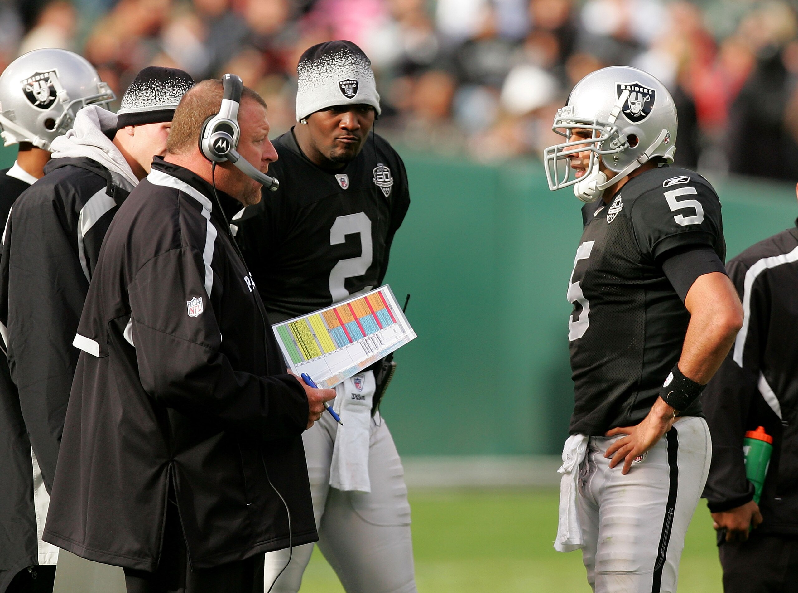 OAKLAND, CA - NOVEMBER 22:  Oakland Raiders head coach Tom Cable speaks to his new starting quarterback Bruce Gradkowski #5 while newly benched quarterback JaMarcus Russell #2 looks on during their game against the Cincinnati Bengals at Oakland-Alameda Co