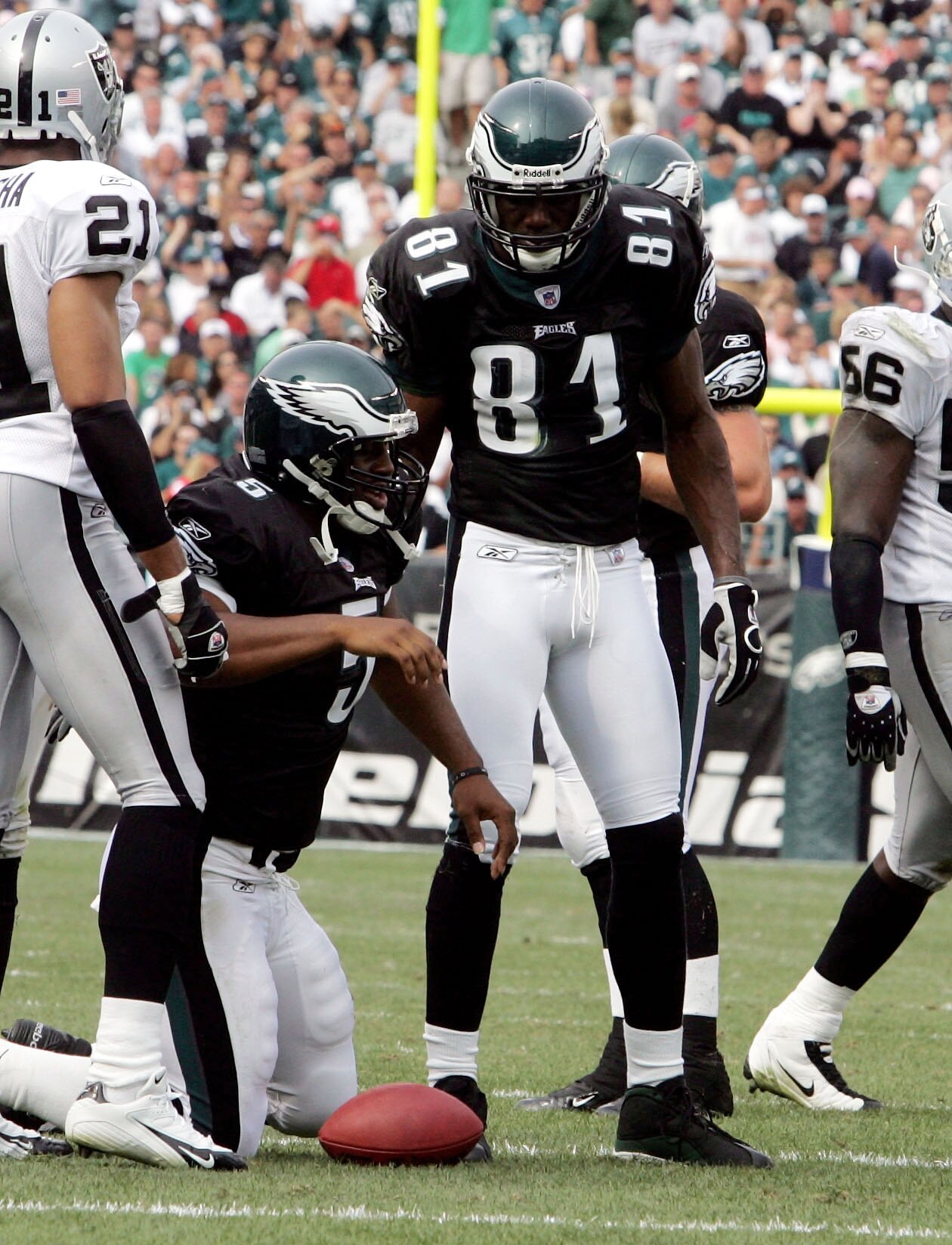 PHILADELPHIA - SEPTEMBER 25: Wide receiver Terrell Owens #81 of the Philadelphia Eagles checks on his quarterback Donovan McNabb #5 after he was hit hard as he ran the ball against the Oakland Raiders during their game on September 25, 2005 at Lincoln Fin