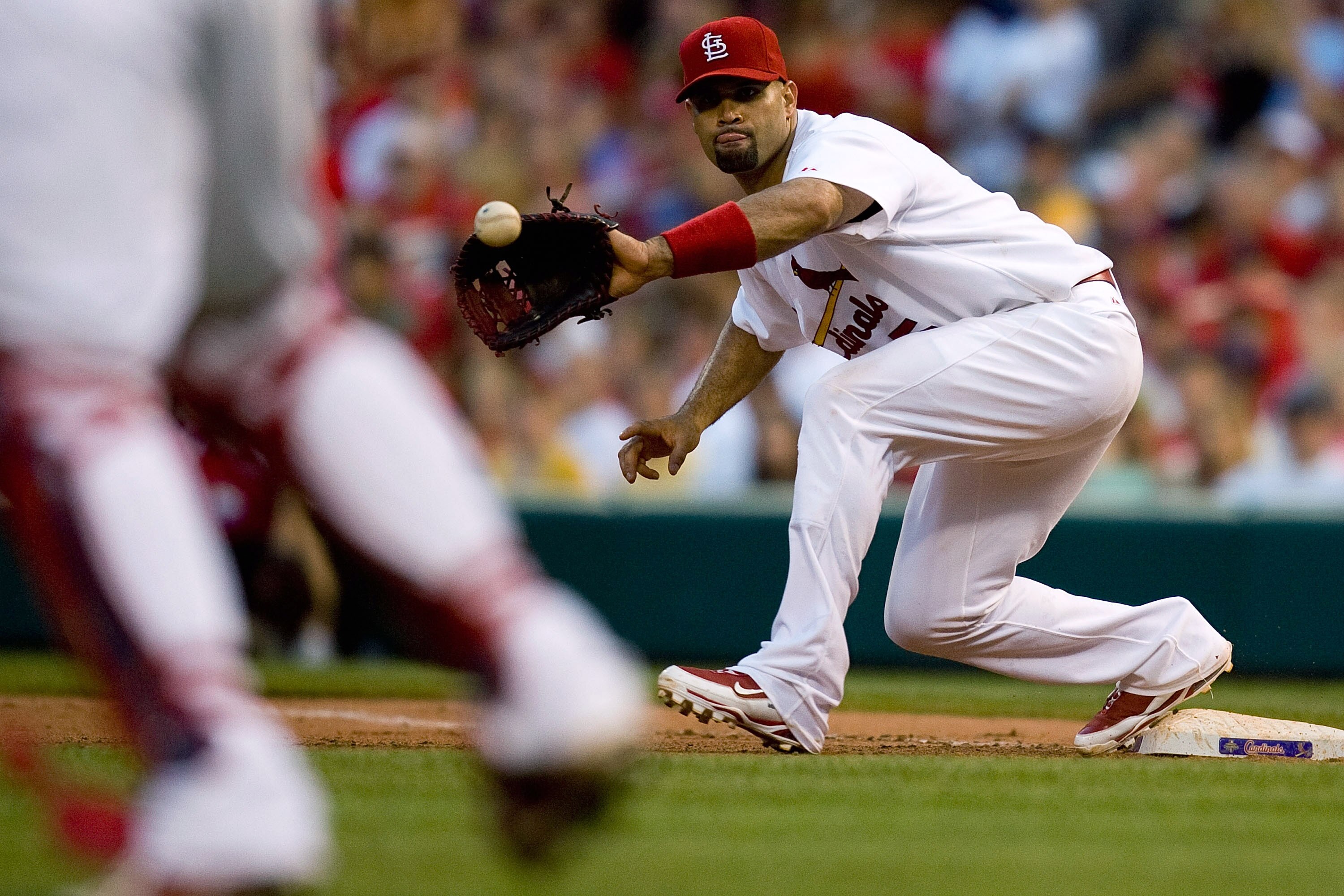ST. LOUIS - JUNE 19: Albert Pujols #5 of the St. Louis Cardinals fields a throw to first base against the Oakland Athletics at Busch Stadium on June 19, 2010 in St. Louis, Missouri.  The Cardinals beat the Athletics 4-3.  (Photo by Dilip Vishwanat/Getty I