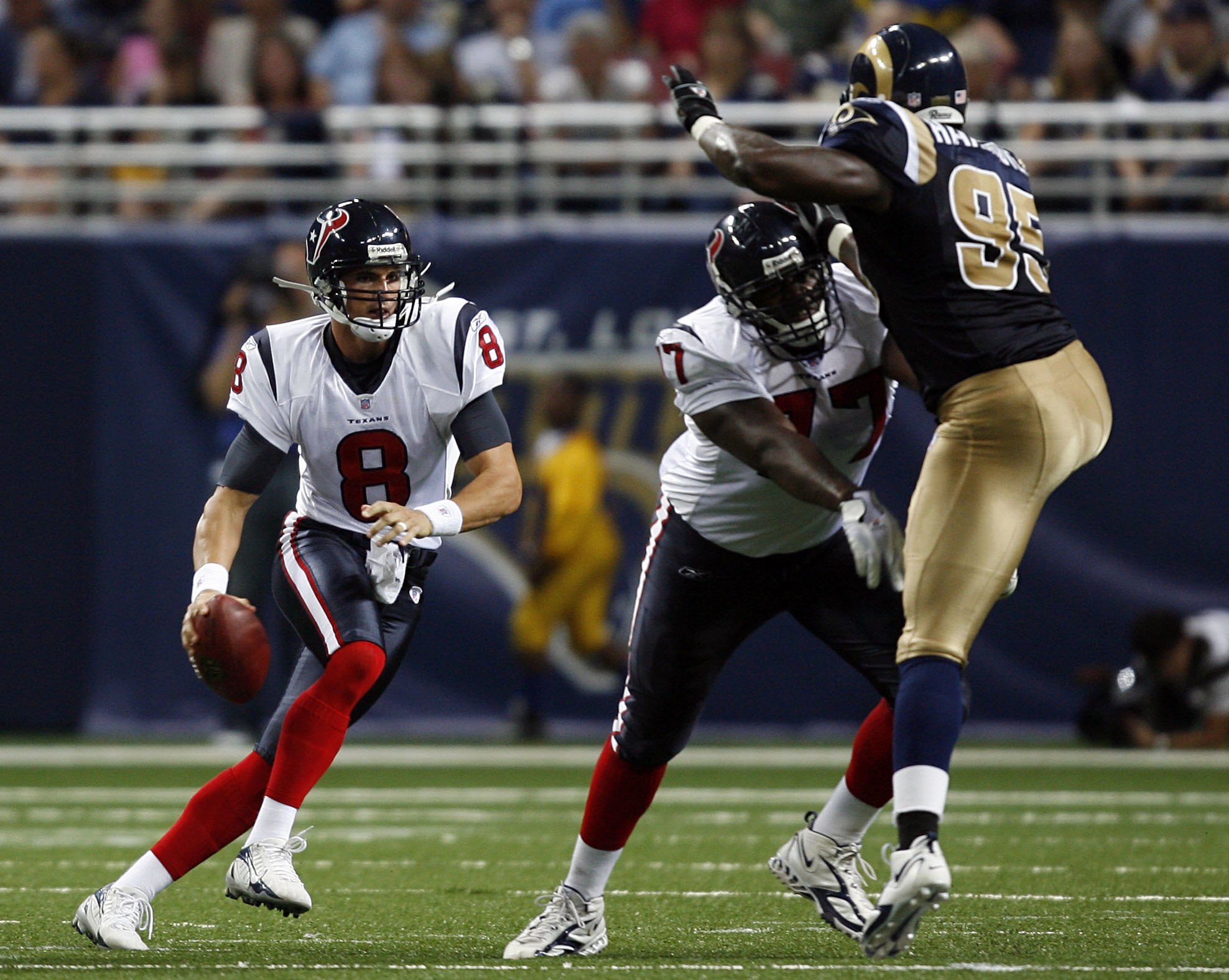 ST. LOUIS - AUGUST 19:  Charles Spencer #77 of the Houston Texans blocks Anthony Hargrove #95 of the St. Louis Rams for teammate David Carr #8 of the Houston Texans on August 19, 2006 at the Edward Jones Dome in St. Louis, Missouri. (Photo by Dilip Vishwa