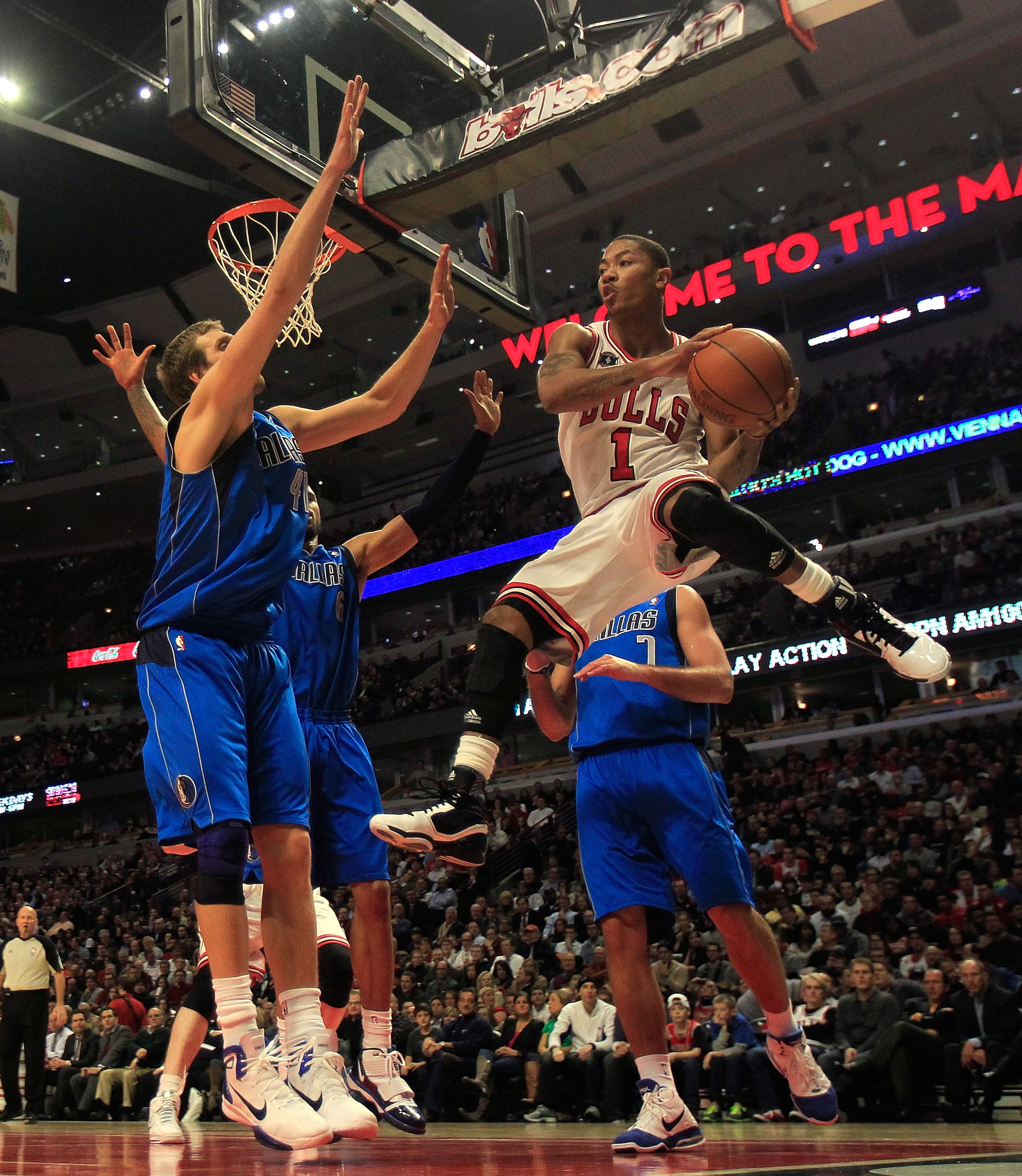 CHICAGO, IL - JANUARY 20: Derrick Rose #1 of the Chicago Bulls leaps to pass the ball around Dirk Nowitzki #41 of the Dallas Mavericks at the United Center on January 20, 2011 in Chicago, Illinois. The Bulls defeated the Mavericks 82-77. NOTE TO USER: Use
