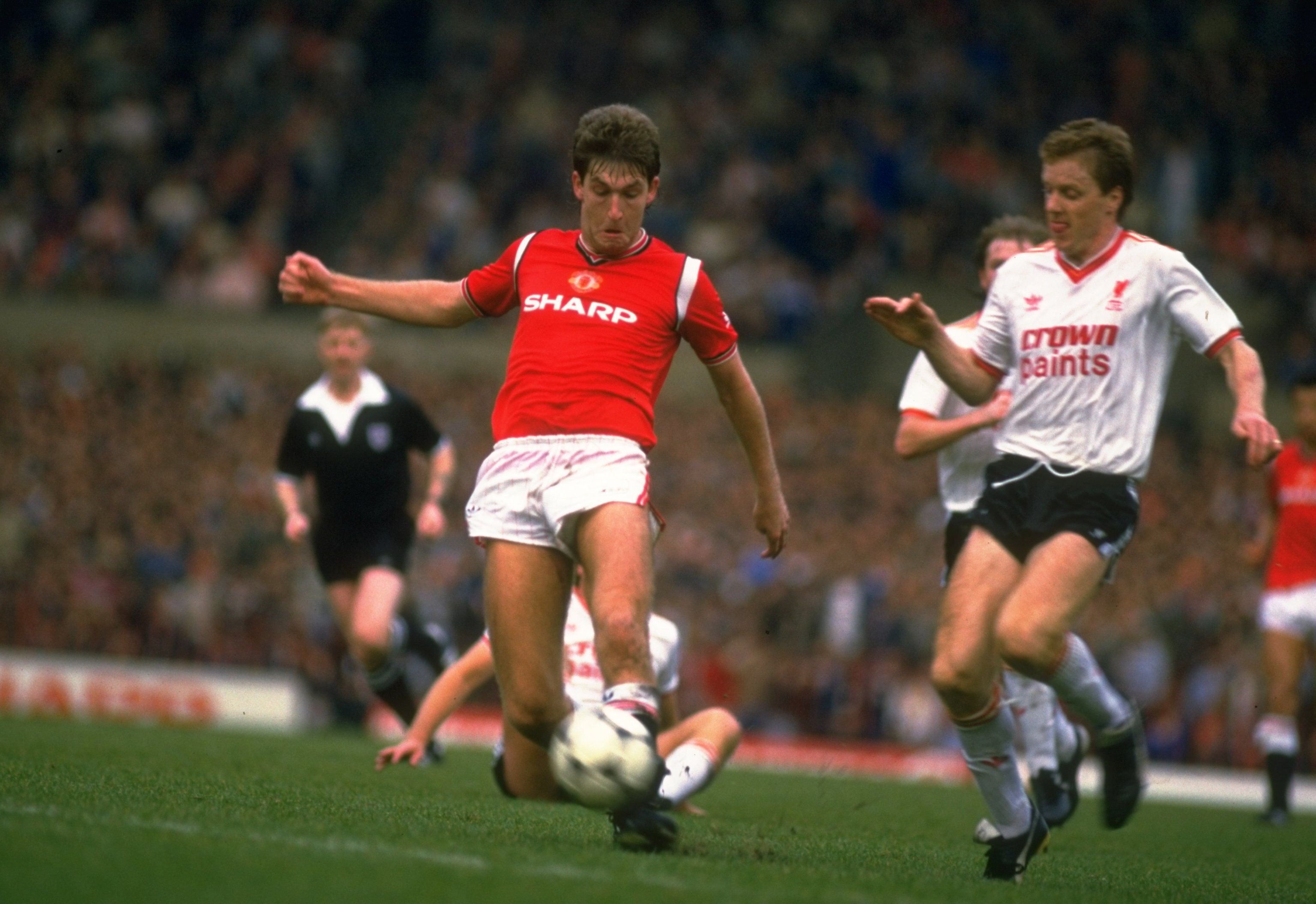 Oct 1985:  Steve Nicholl (right) of Liverpool comes in to tackle Norman Whiteside (left) of Manchester United during a Canon League Division One match at Old Trafford in Manchester, England. The match ended in a 1-1 draw.   \ Mandatory Credit: Allsport UK