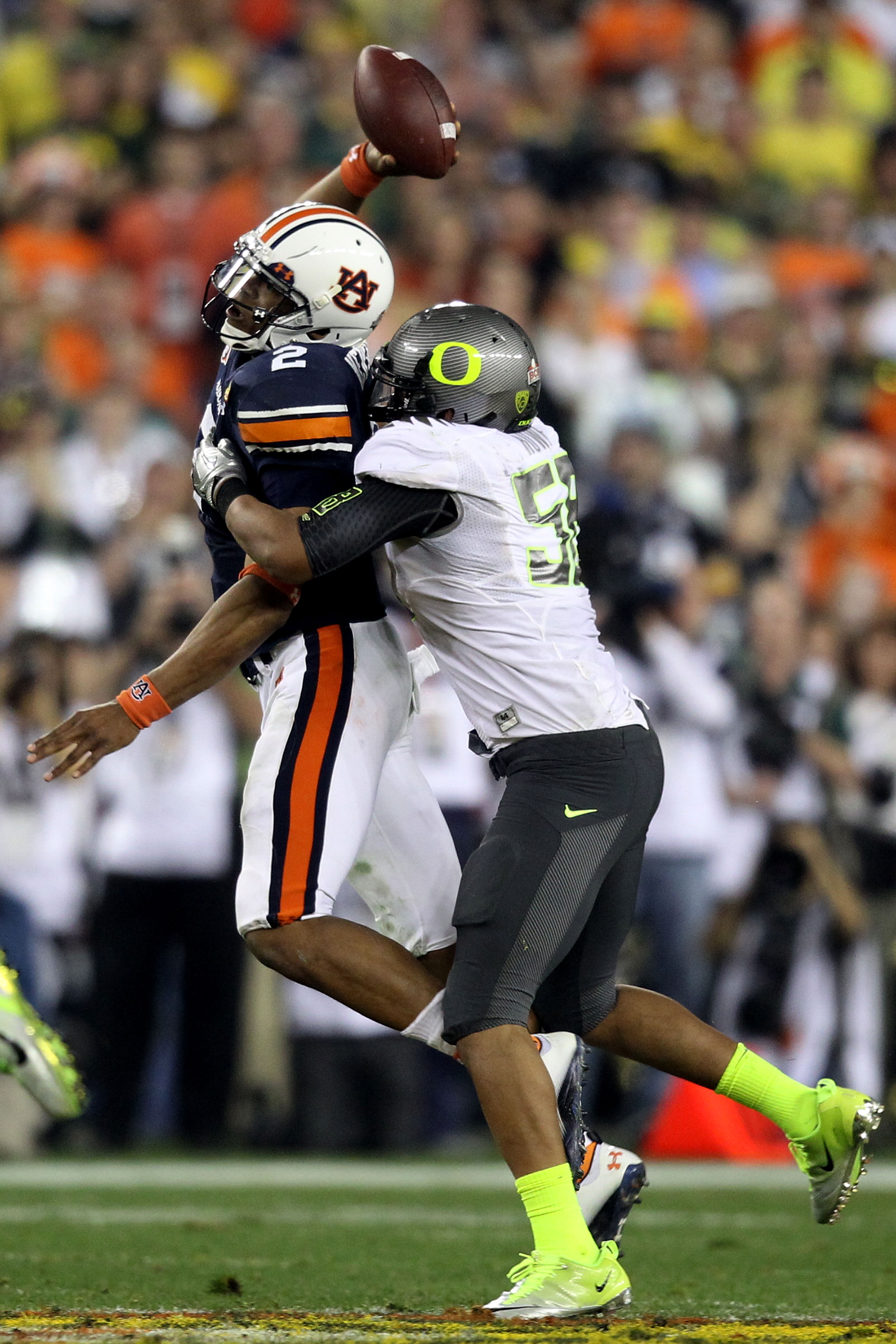 GLENDALE, AZ - JANUARY 10:  Cameron Newton #2 of the Auburn Tigers tries to pass as Kenny Rowe #58 of the Oregon Ducks tries to tackle him during the Tostitos BCS National Championship Game at University of Phoenix Stadium on January 10, 2011 in Glendale,