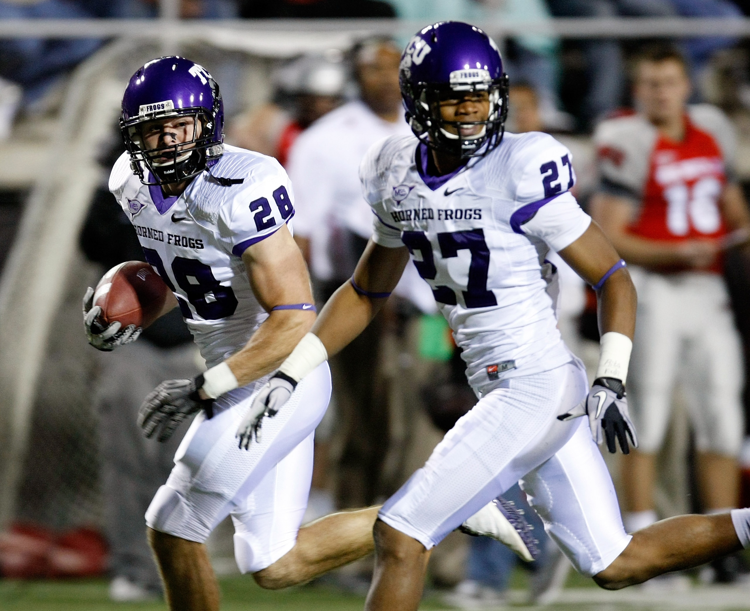 LAS VEGAS - OCTOBER 30:  Colin Jones #28 of the Texas Christian University Horned Frogs runs for a 30-yard touchdown after making an interception against the UNLV Rebels as his teammate Jason Teague #27 runs with him during the second quarter of their gam