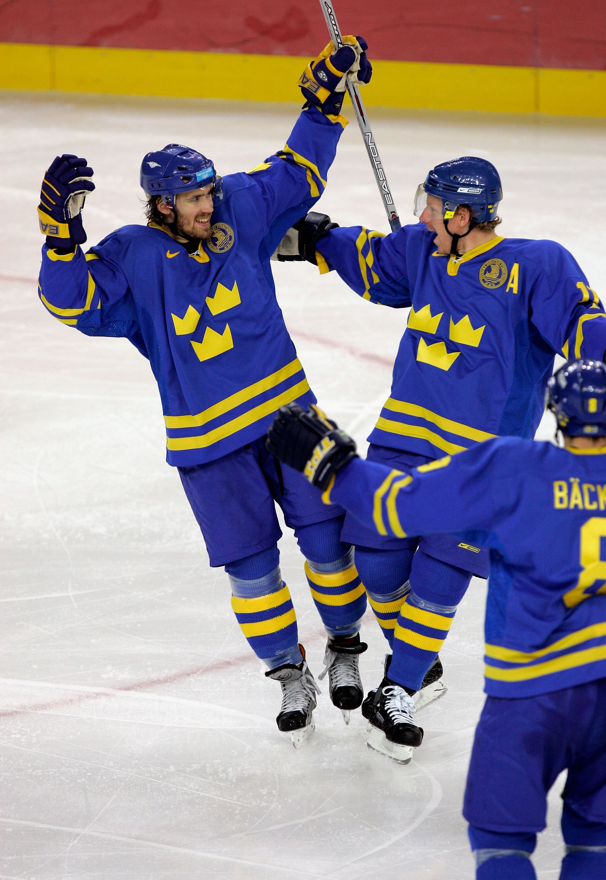 TURIN, ITALY - FEBRUARY 26:  Henrik Zetterberg #40 of Sweden is congratulated by teammates Daniel Alfredsson #11 and Christian Backman #8 after scoring in the second period to make the score 1-1 during the final of the men's ice hockey match between Finla
