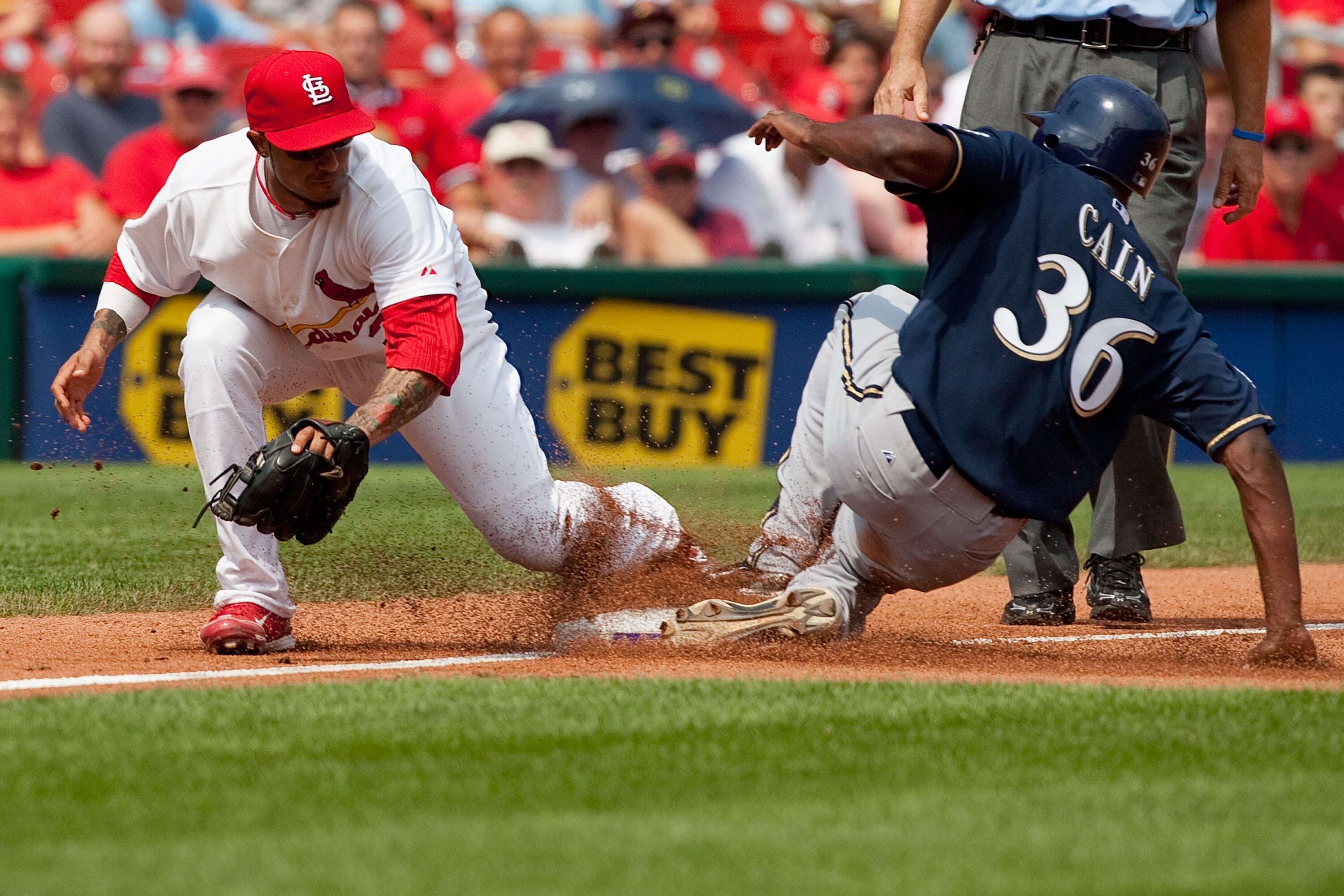 ST. LOUIS - AUGUST 18: Lorenzo Cain #36 of the Milwaukee Brewers steals third base against Felipe Lopez #3 of the St. Louis Cardinals at Busch Stadium on August 18, 2010 in St. Louis, Missouri.  The Brewers beat the Cardinals 3-2.  (Photo by Dilip Vishwan