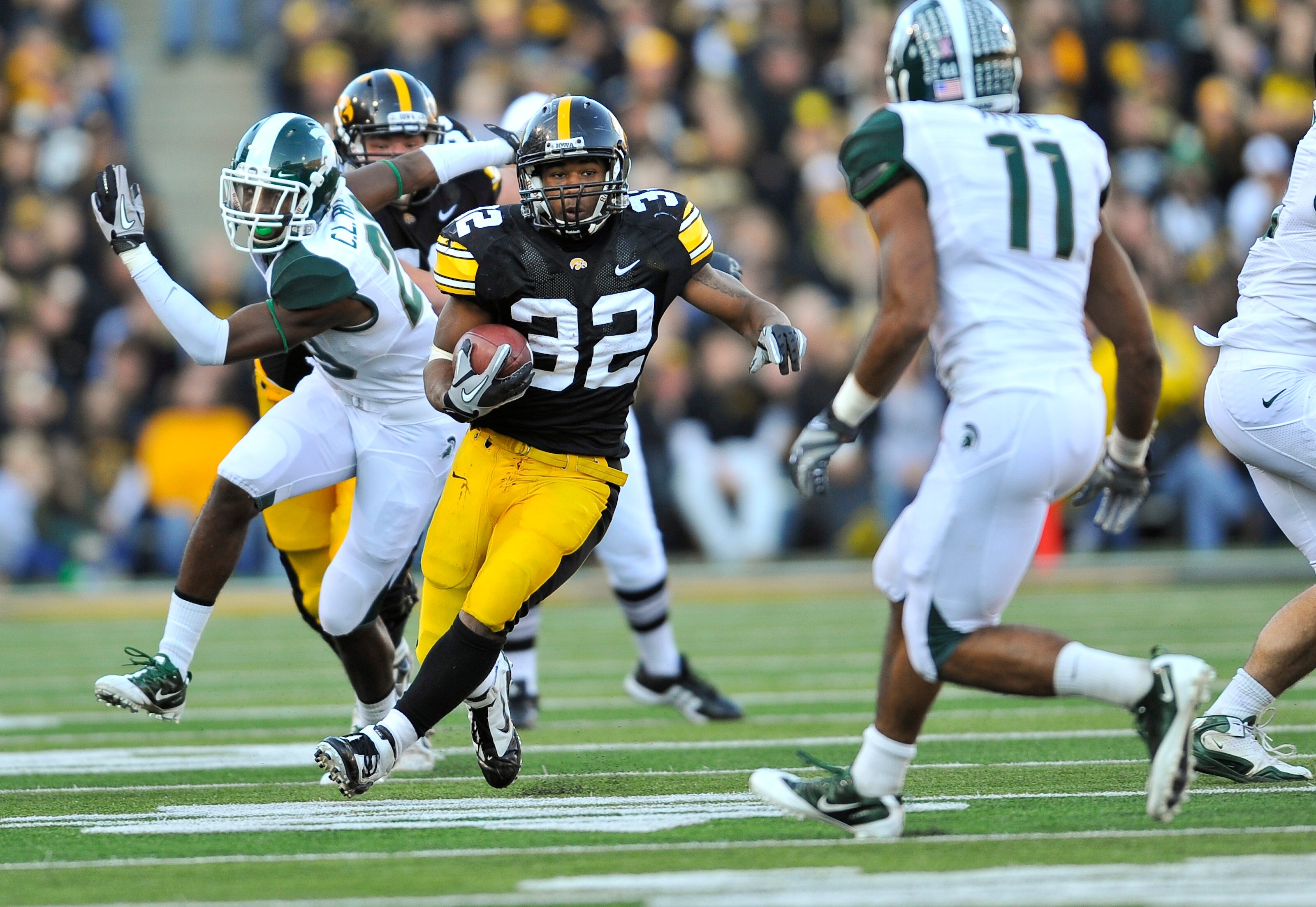 IOWA CITY, IA - OCTOBER 30:  Running back Adam Robinson #32 of the University of Iowa Hawkeyes rushes for yards past safety Marcu Hyde #11 of the Michigan State Spartans during the second half of play at Kinnick Stadium on October 30, 2010 in Iowa City, I