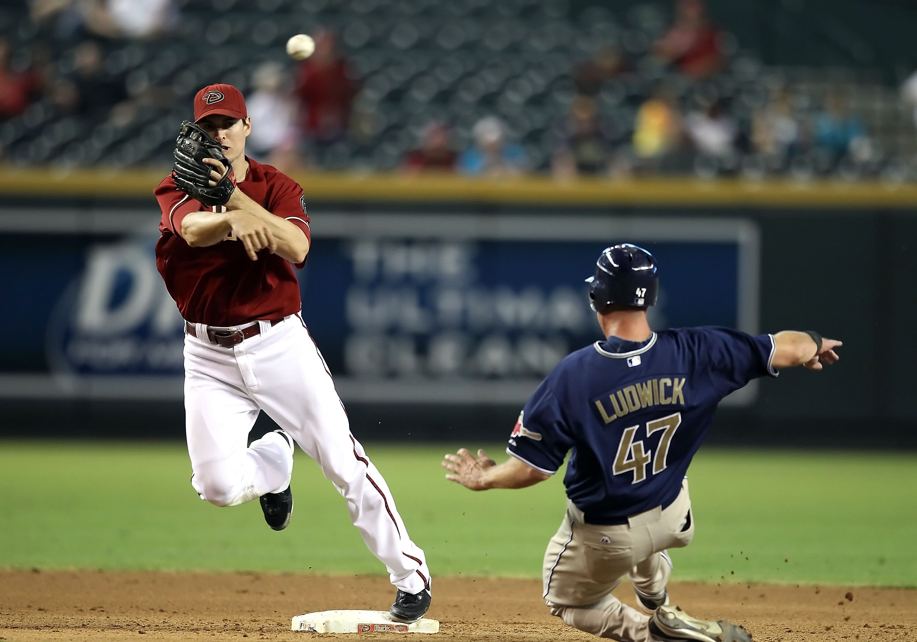 PHOENIX - SEPTEMBER 01:  Infielder Kelly Johnson #2 of the Arizona Diamondbacks throws over the sliding Ryan Ludwick #47 of the San Diego Padres attempting to complete a double play during the Major League Baseball game at Chase Field on September 1, 2010