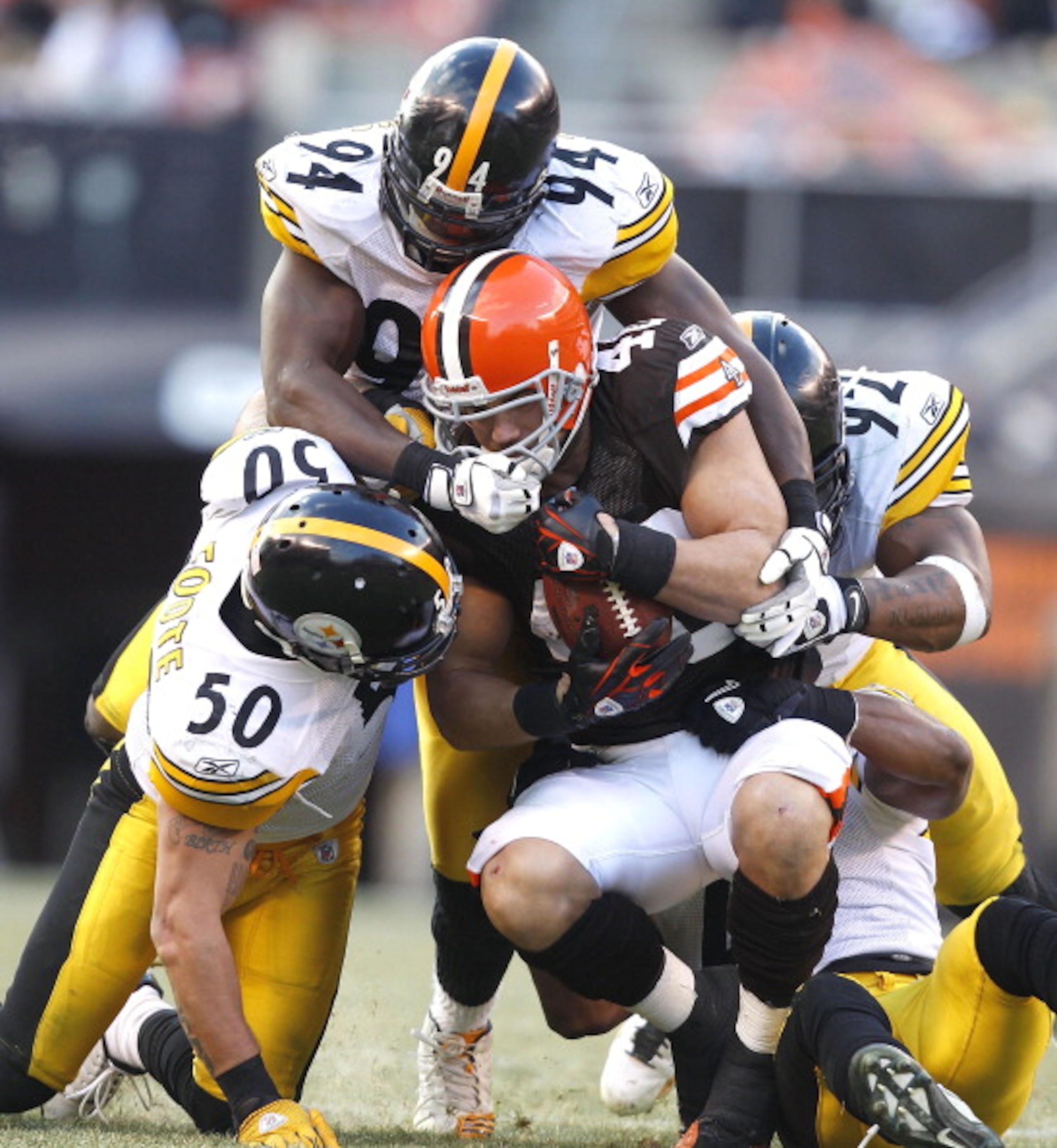 CLEVELAND, OH - JANUARY 02:  Defenders Larry Foote #50, Lawrence Timmons #94 and James Harrison #92 of the Pittsburgh Steelers tackle tailback Peyton Hillis #40 of the Cleveland Browns at Cleveland Browns Stadium on January 2, 2011 in Cleveland, Ohio.  (P