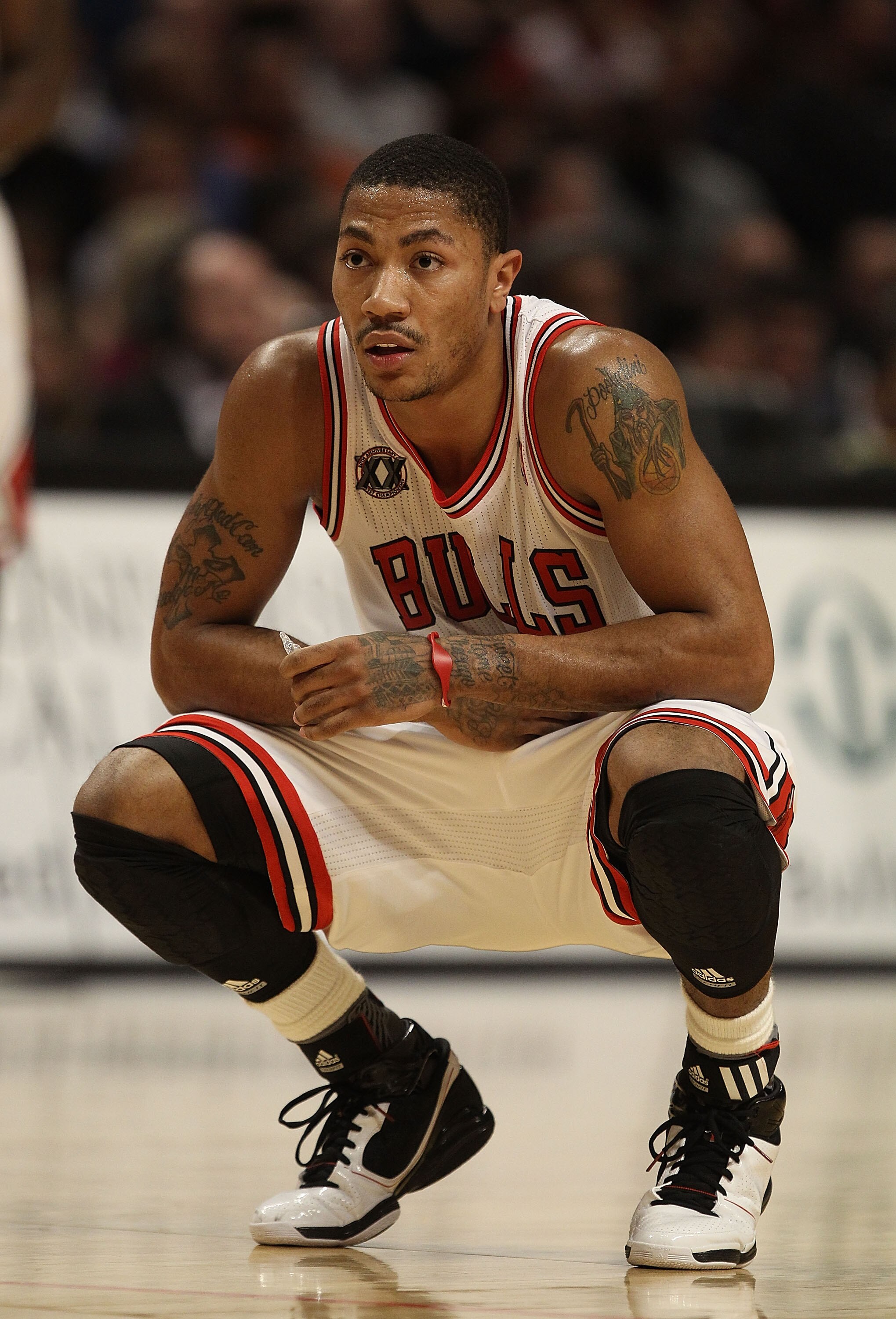 CHICAGO, IL - JANUARY 28: Derrick Rose #1 of the Chicago Bulls, playing in pain from an ulcer, holds his stomach as a teammate shoots a free-throw against the Orlando Magic at the United Center on January 28, 2011 in Chicago, Illinois. The Bulls defeated