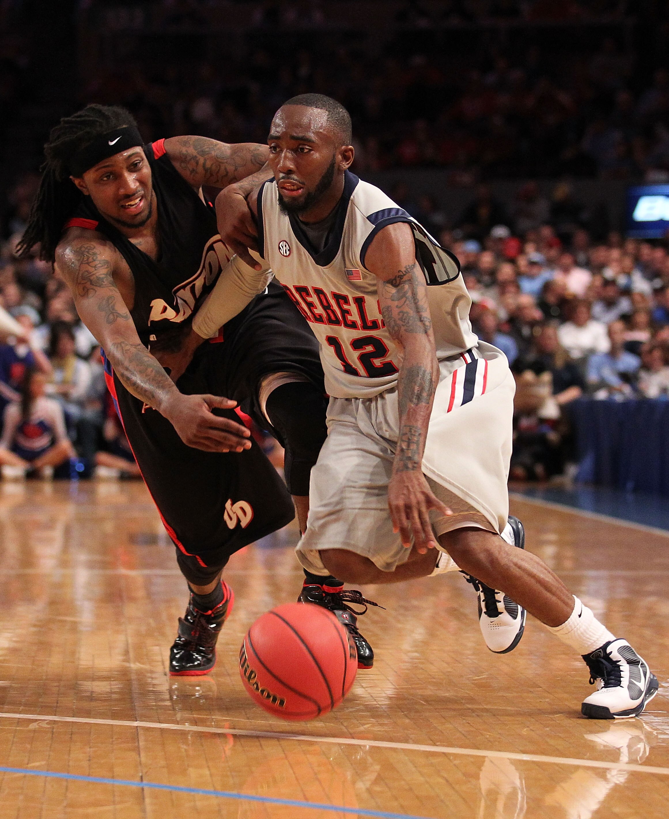 NEW YORK - MARCH 30:  Chris Warren #12 of Ole Miss drives past London Warren #1 of the Dayton Flyers during their semi final at Madison Square Garden on March 30, 2010 in New York, New York.  (Photo by Nick Laham/Getty Images)