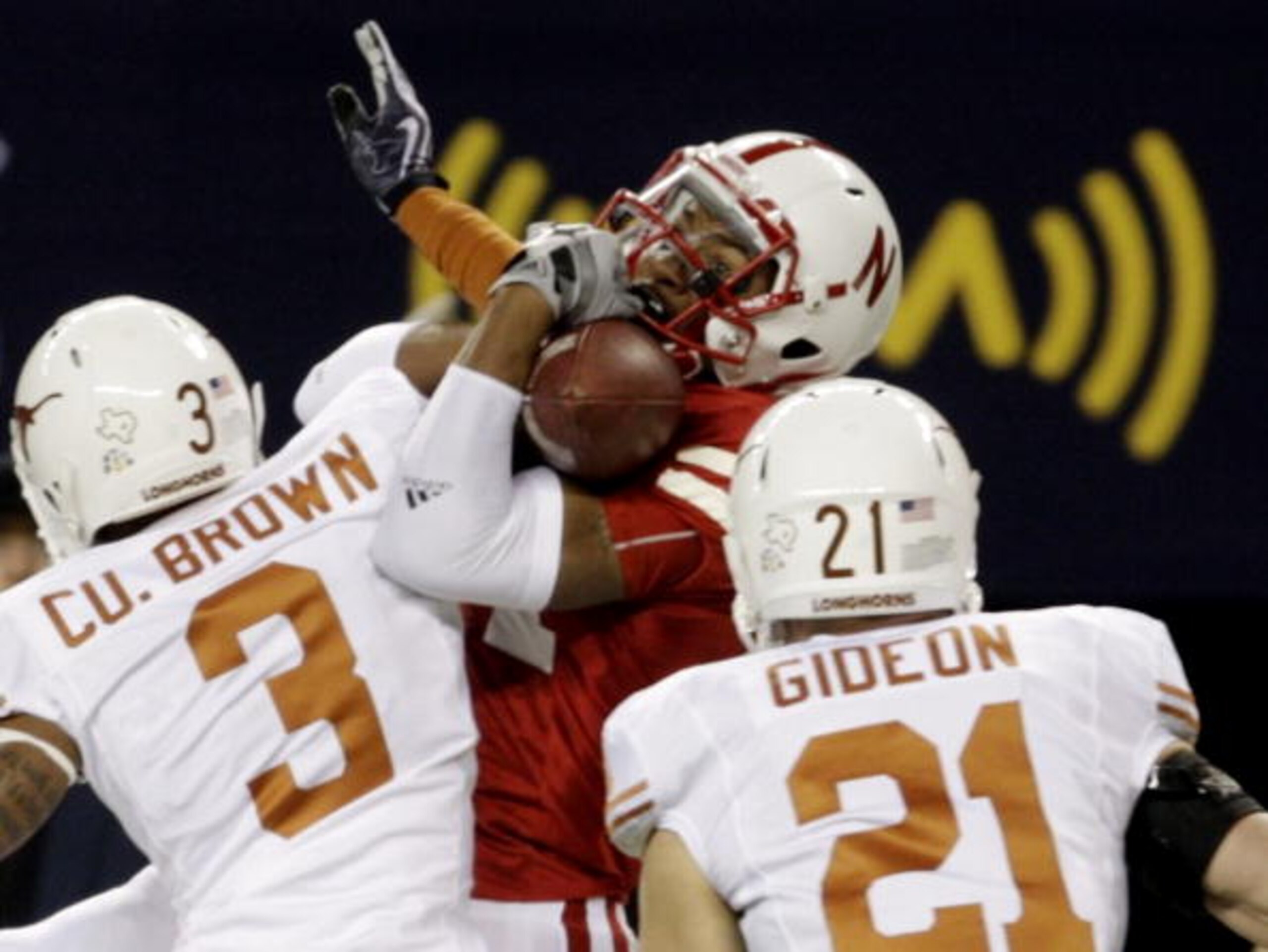 ARLINGTON, TX - DECEMBER 5:  Wide receiver Brandon Kinnie #84 of the Nebraska Cornhuskers cannot hold on for an incomplete pass in front of Curtis Brown #3 and Blake Gideon #21 of the Texas Longhorns in the first quarter of the game at Cowboys Stadium on