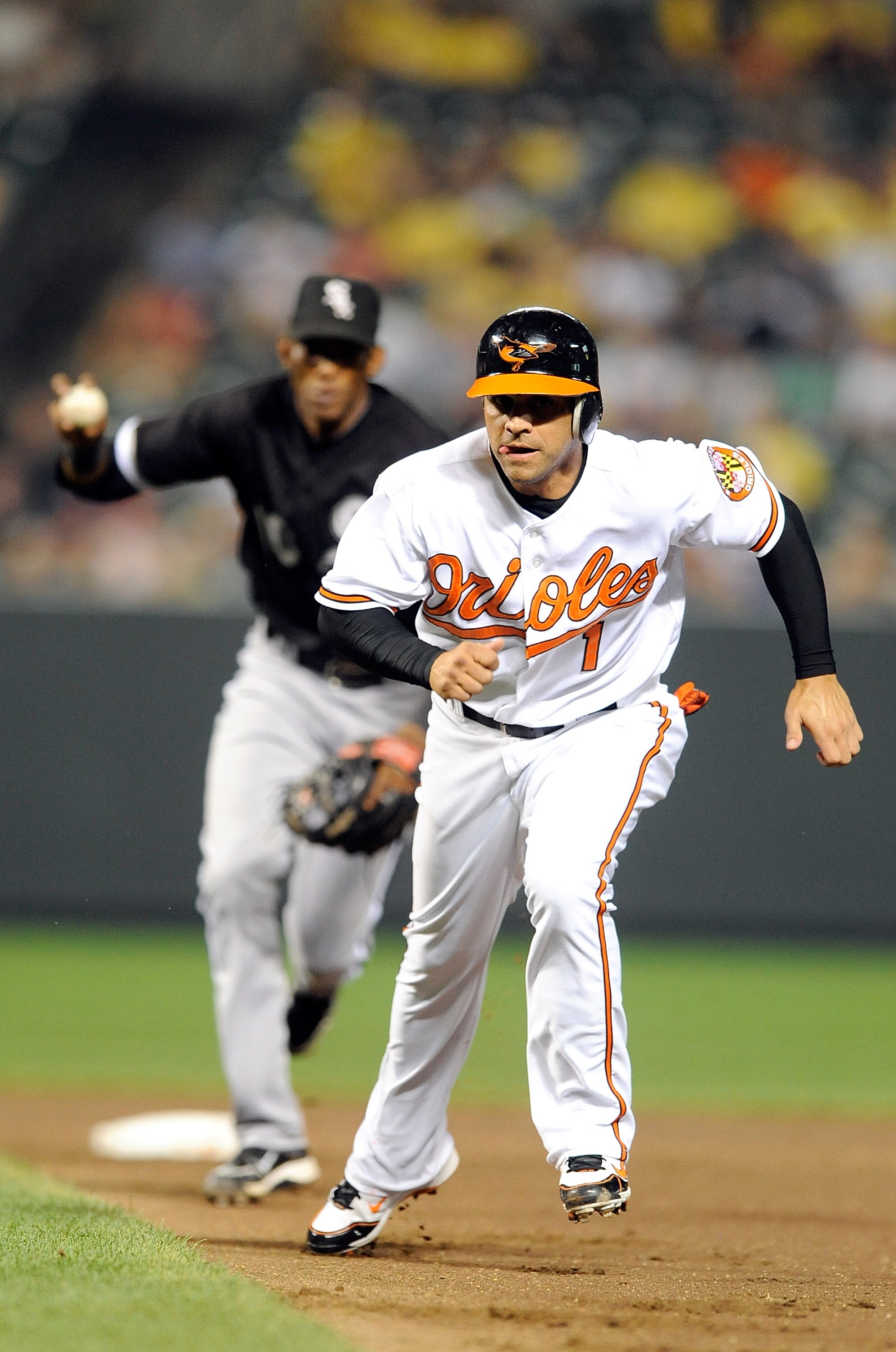 BALTIMORE - AUGUST 09:  Brian Roberts #1 of the Baltimore Orioles is caught in a run-down and tagged out by Alexei Ramirez #10 of the Chicago White Sox at Camden Yards on August 9, 2010 in Baltimore, Maryland. The Orioles won the game 3-2.  (Photo by Greg