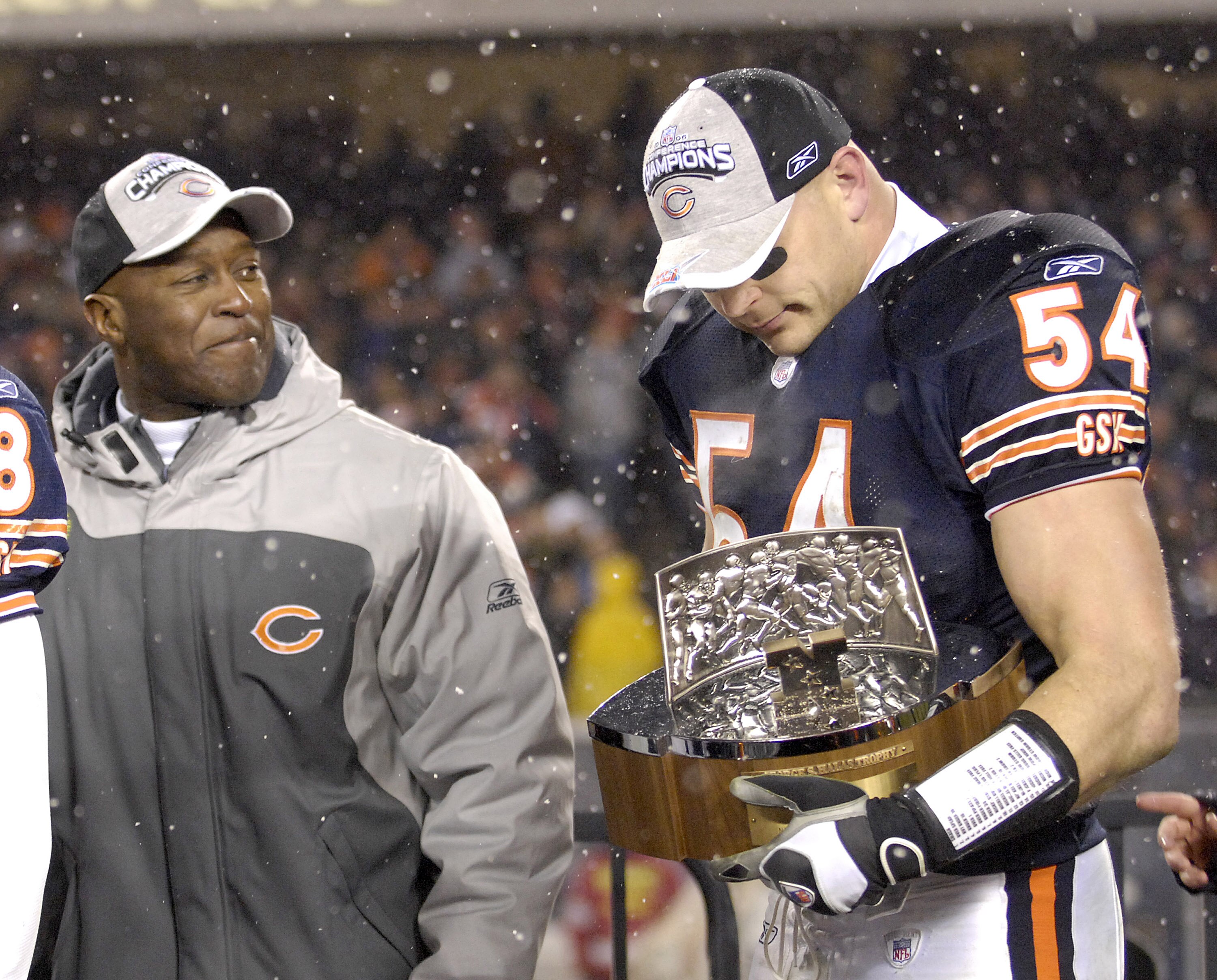 Bears coach Lovie Smith looks on as Brian Urlacher holds the George S. Halas trophy after the Bears won the 2007 NFC Championship game between the Chicago Bears and New Orleans Saints at Soldier Field in Chicago, Illinois on January 21, 2007.  (Photo by A
