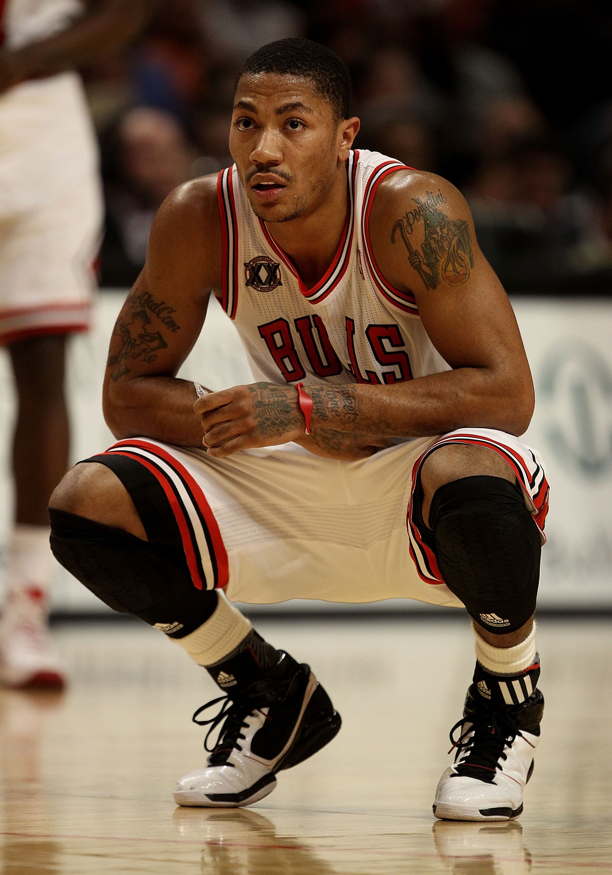 CHICAGO, IL - JANUARY 28:  Derrick Rose #1 of the Chicago Bulls, playing in pain from an ulcer, holds his stomach as a teammate shoots a free-throw against the Orlando Magic at the United Center on January 28, 2011 in Chicago, Illinois. The Bulls defeated