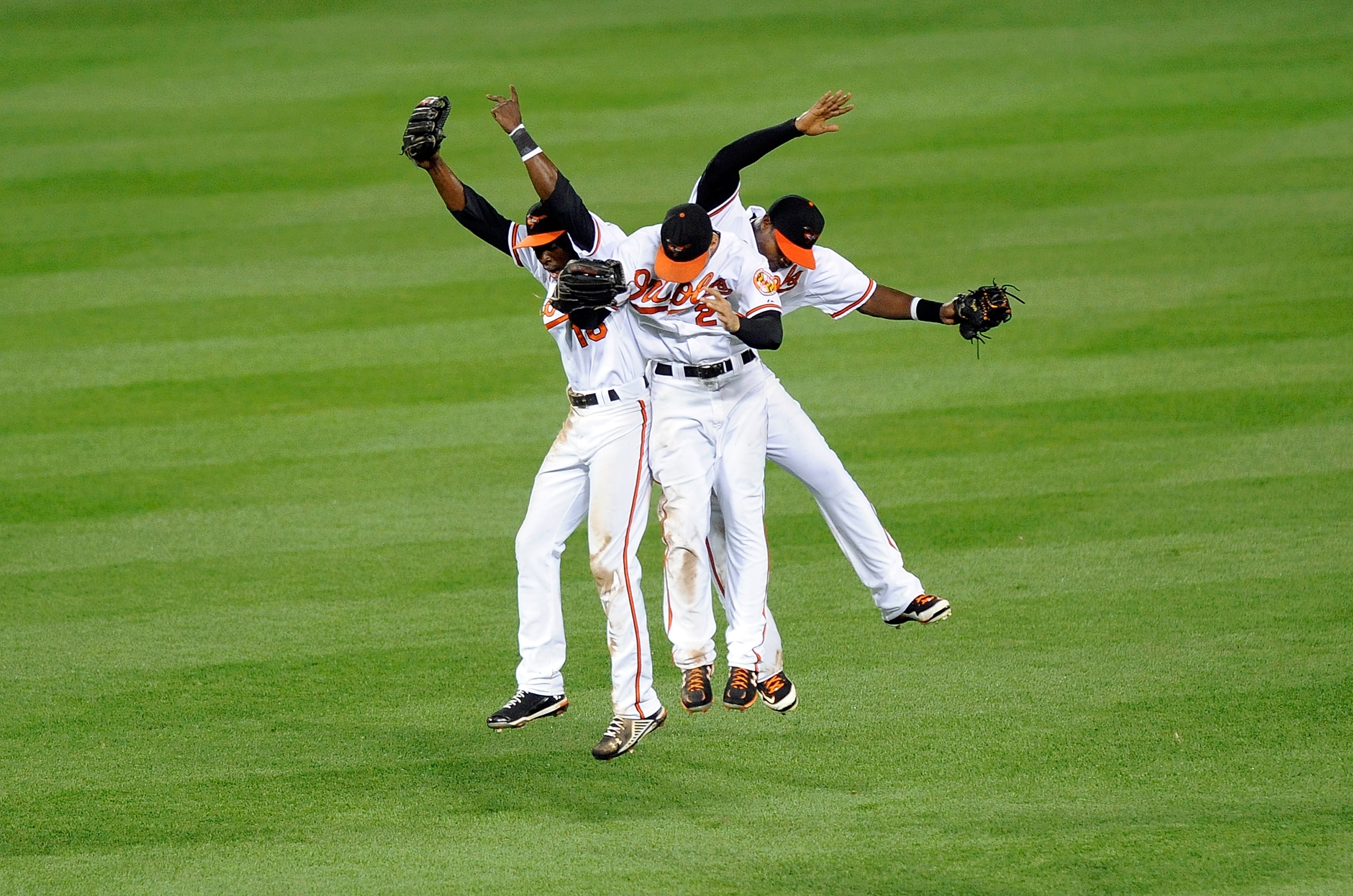 BALTIMORE - AUGUST 04:  Felix Pie #18, Nick Markakis #21 and Adam Jones #10 of the Baltimore Orioles celebrate after a 9-7 victory against the Los Angeles Angels of Anaheim at Camden Yards on August 4, 2010 in Baltimore, Maryland.  (Photo by Greg Fiume/Ge