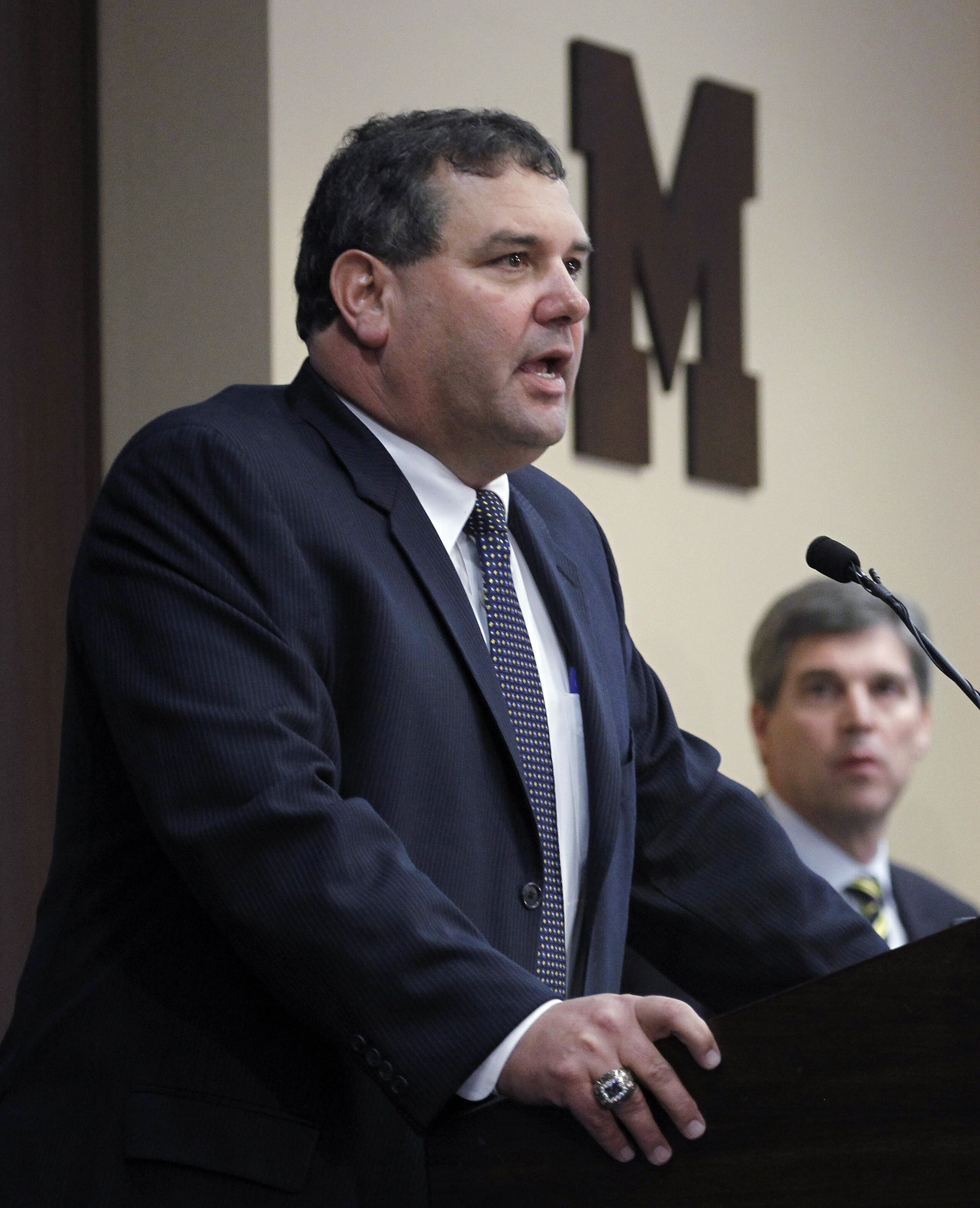 ANN ARBOR, MI - JANUARY 12: New University of Michigan head football coach Brady Hoke (L) speaks to the media as, Athletic Director Dave Brandon looks on, after introducing Hoke as the nineteenth Michigan head football coach in Michigan history at the Ju ANN ARBOR, MI - JANUARY 12: New University of Michigan head football coach Brady Hoke (L) speaks to the media as, Athletic Director Dave Brandon looks on, after introducing Hoke as the nineteenth Michigan head football coach in Michigan history at the Ju