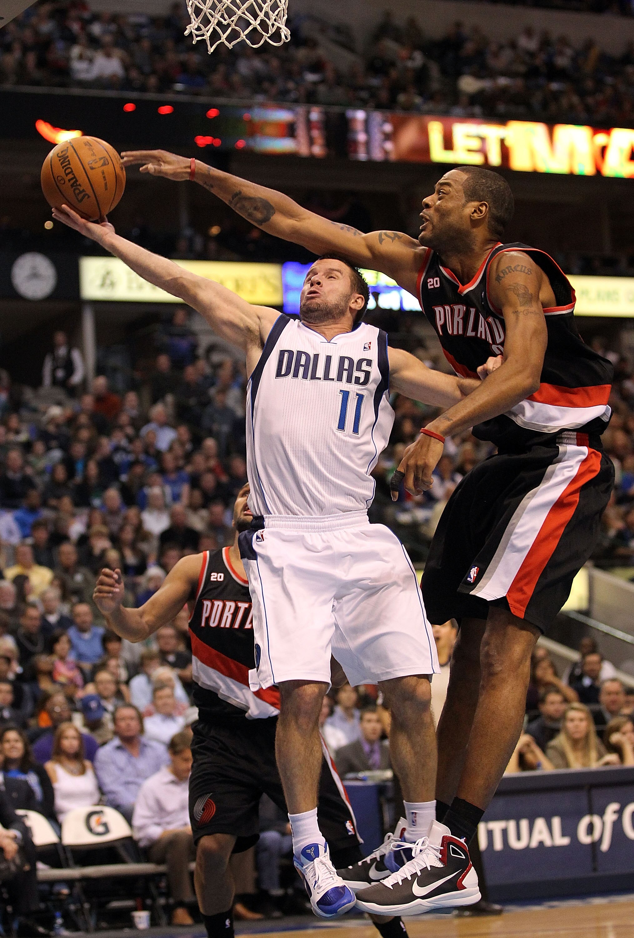 DALLAS, TX - JANUARY 04:  Guard Jose Juan Barea #11 of the Dallas Mavericks takes a shot against Marcus Camby #23 of the Portland Trail Blazers at American Airlines Center on January 4, 2011 in Dallas, Texas.  NOTE TO USER: User expressly acknowledges and