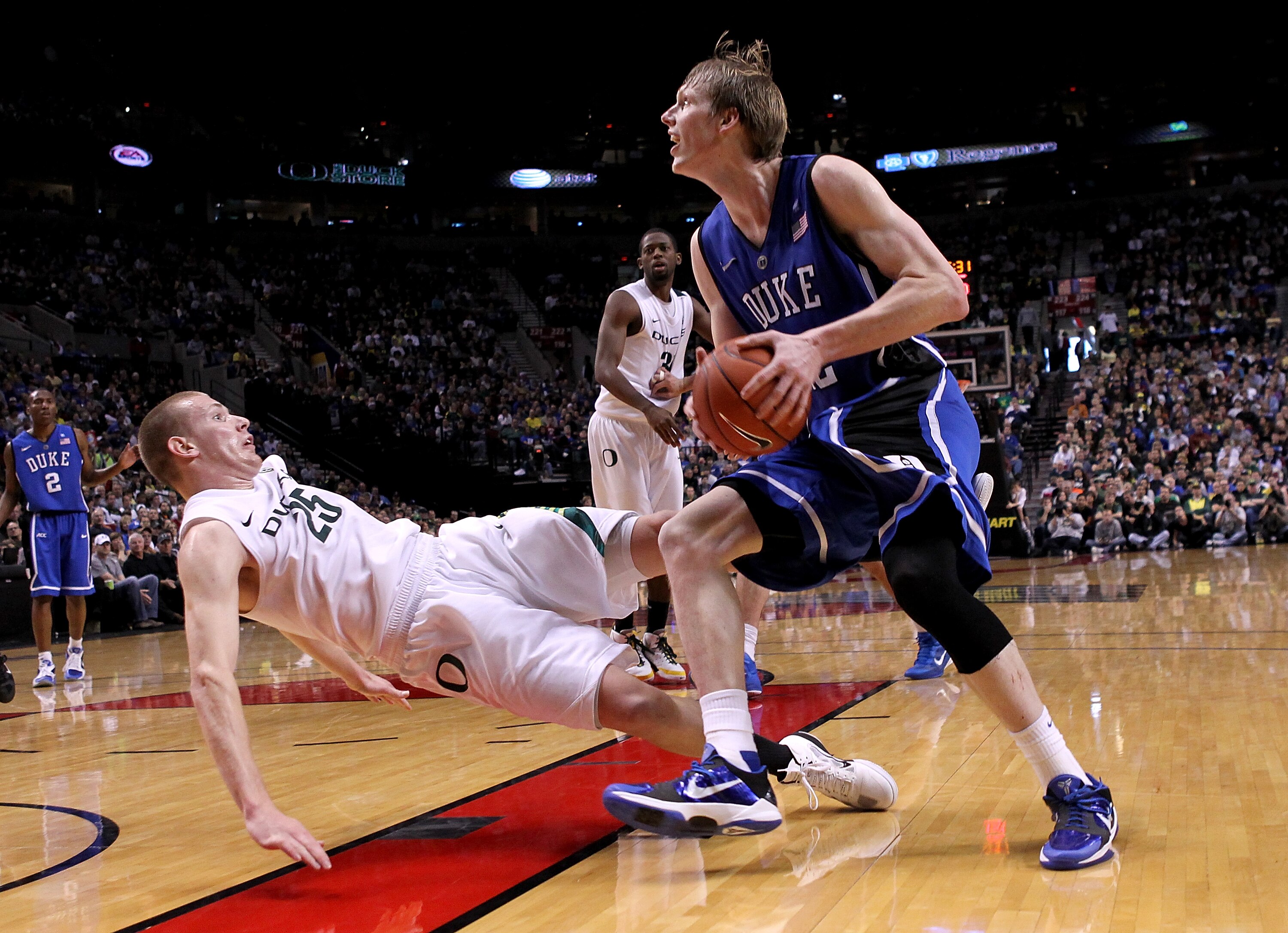 PORTLAND, OR - NOVEMBER 27:  Kyle Singler #12 of the Duke Blue Devils drives against his brother E. J. Singler #25 of the Oregon Ducks on November 27, 2010 at the Rose Garden in Portland, Oregon.  (Photo by Jonathan Ferrey/Getty Images)