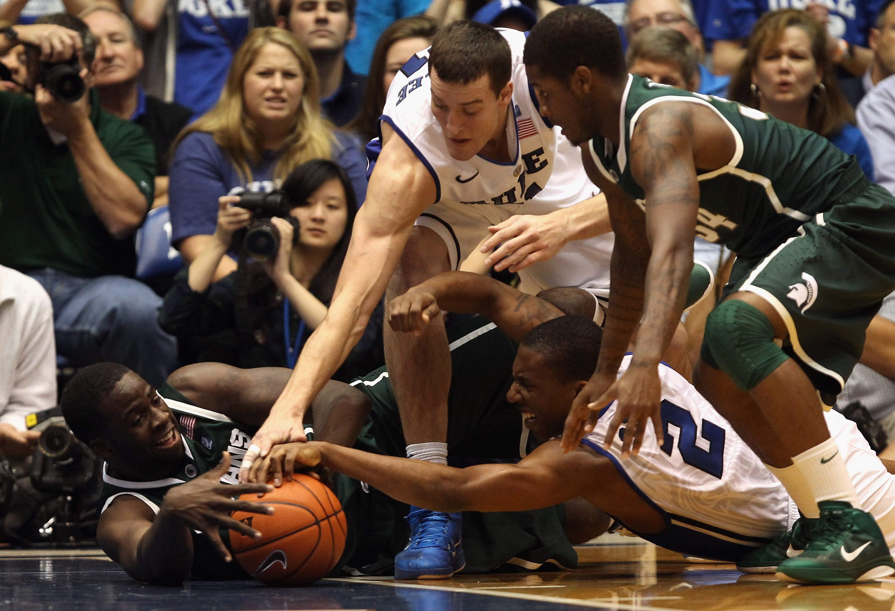 DURHAM, NC - DECEMBER 01:  Draymond Green #23 and teammate Korie Lucious #34 of the Michigan State Spartans fight for a loose ball with teammates Nolan Smith #2 and Miles Plumlee of the Duke Blue Devils during their game at Cameron Indoor Stadium on Decem