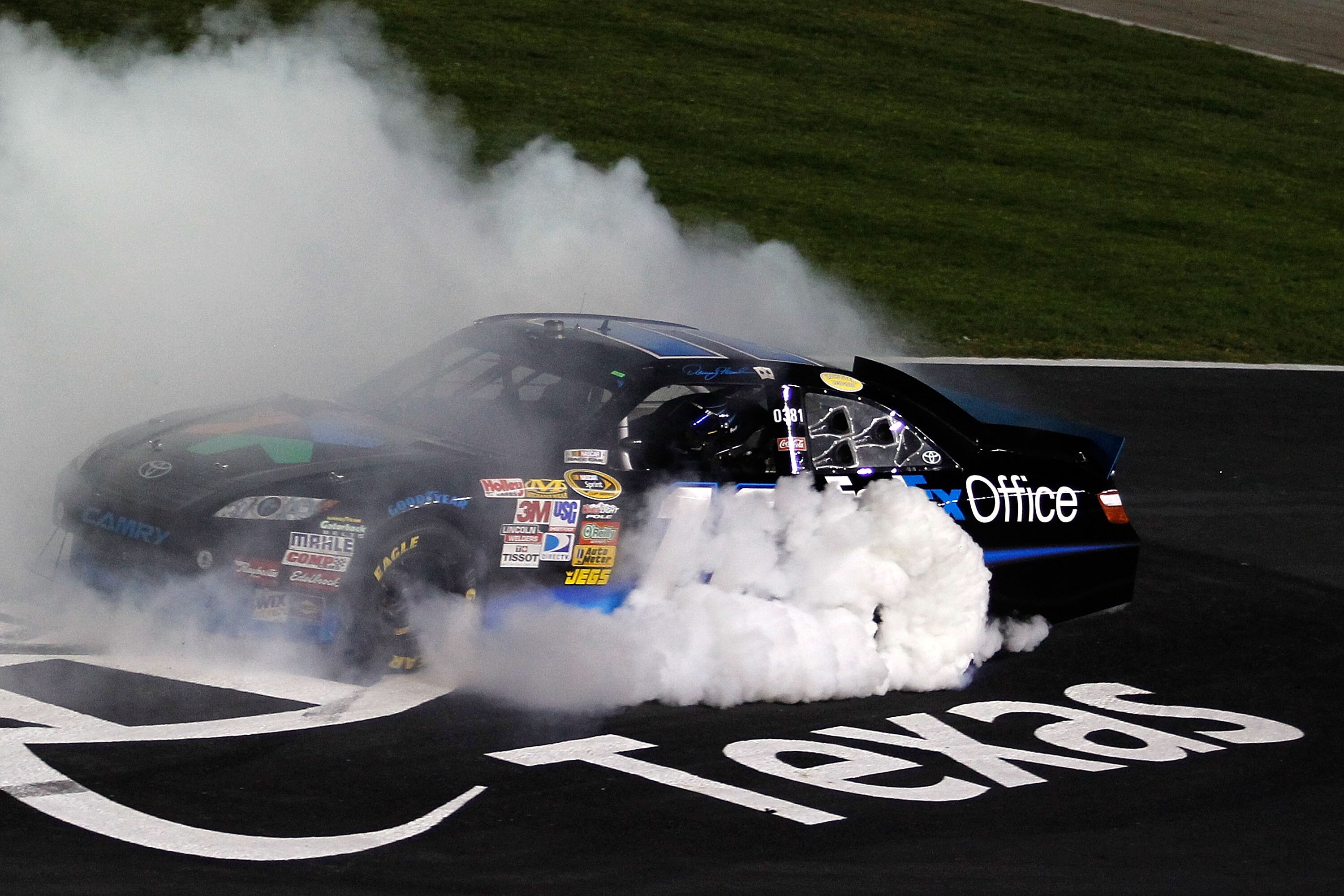 FORT WORTH, TX - NOVEMBER 07:  Denny Hamlin, driver of the #11 FedEx Office Toyota, celebrates with a burn out after winning the NASCAR Sprint Cup Series AAA Texas 500 at Texas Motor Speedway on November 7, 2010 in Fort Worth, Texas.  (Photo by Todd Warsh
