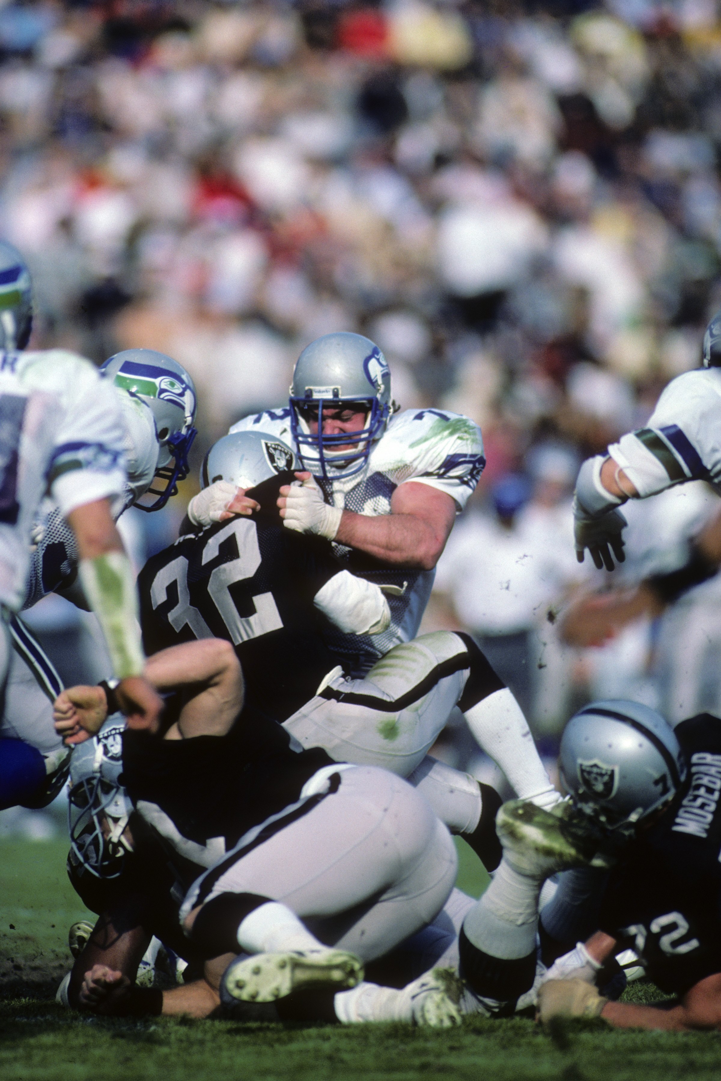 LOS ANGELES, CA - DECEMBER 15:  Defensive tackle Joe Nash #72 of the Seattle Seahawks tackles Los Angeles Raiders running back Marcus Allen #32 during the game at Los Angeles Memorial Coliseum on December 15, 1985 in Los Angeles, California.  The Raiders