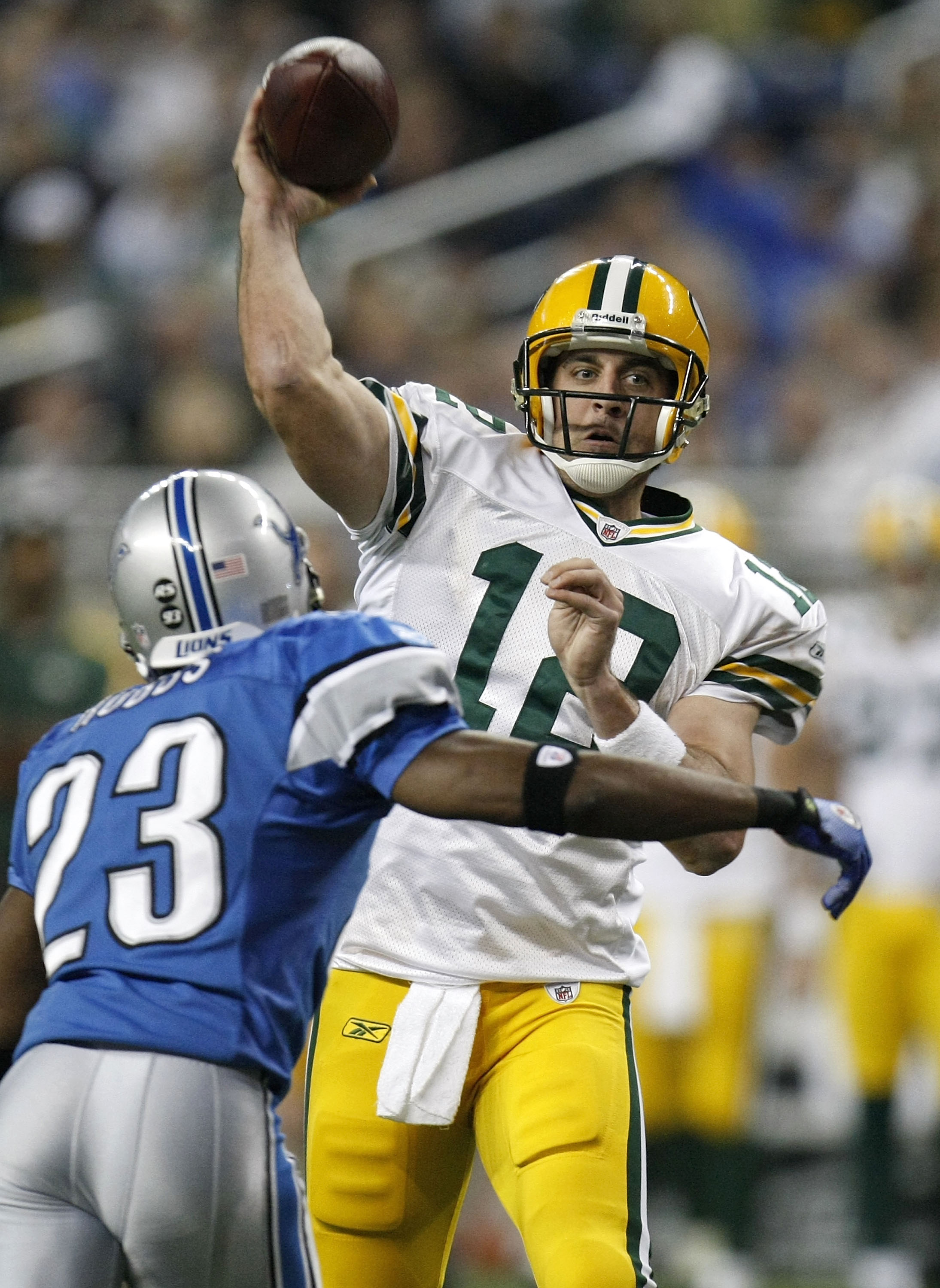 DETROIT , MI - NOVEMBER 26:  Aaron Rodgers #12 of the Green Bay Packers throws a third quarter touchdown behind Kevin Hobbs #23 of the Detroit Lions on November 26, 2009 at Ford Field in Detroit, Michigan. Green Bay won the game 34-12. (Photo by Gregory S