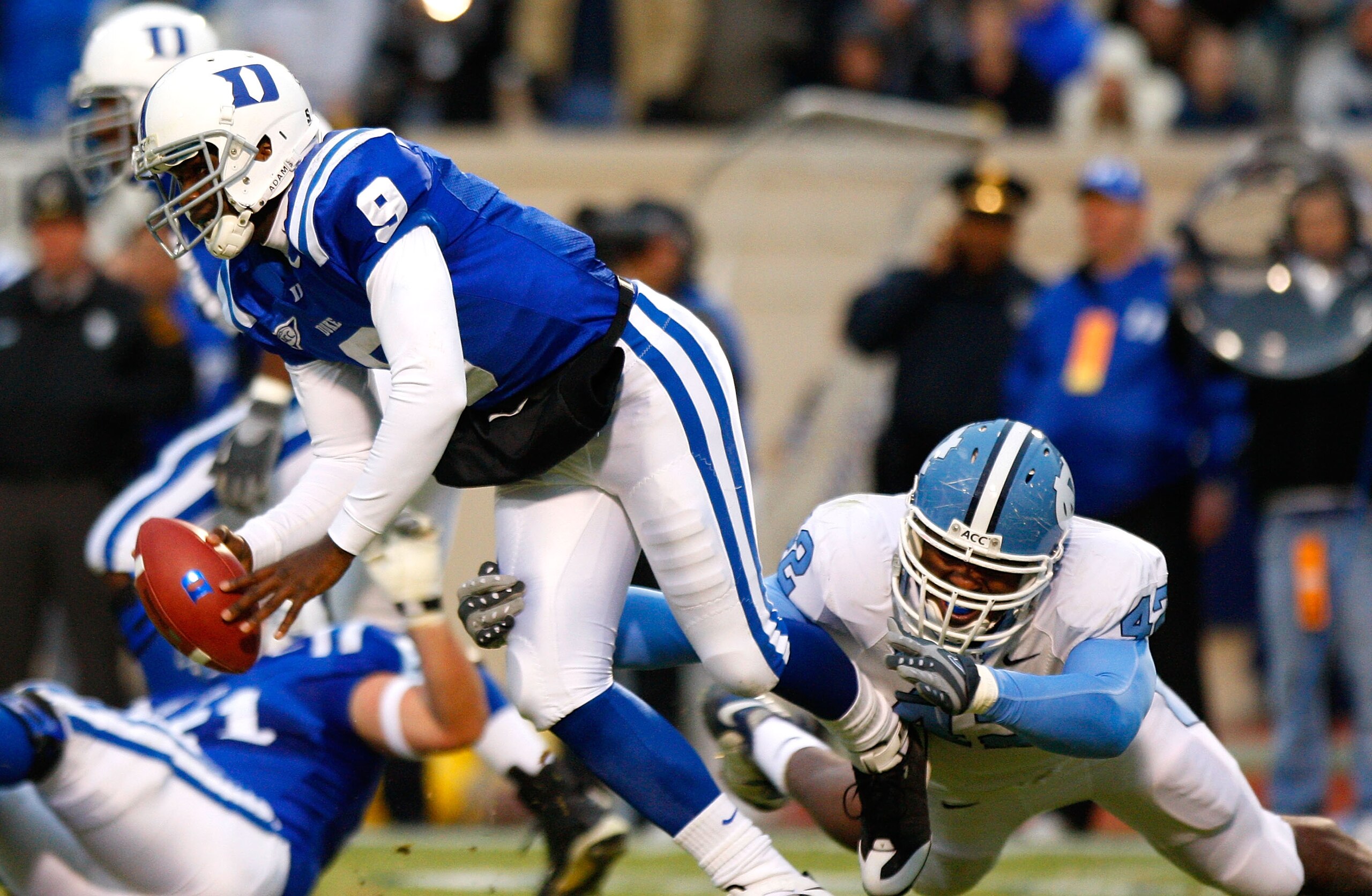 DURHAM, NC - NOVEMBER 29:  Quarterback Thaddeus Lewis #9 of the Duke Blue Devils is sacked by Robert Quinn #42 of the North Carolina Tar Heels during the game at Wallace Wade Stadium on November 29, 2008 in Durham, North Carolina.  (Photo by Kevin C. Cox/