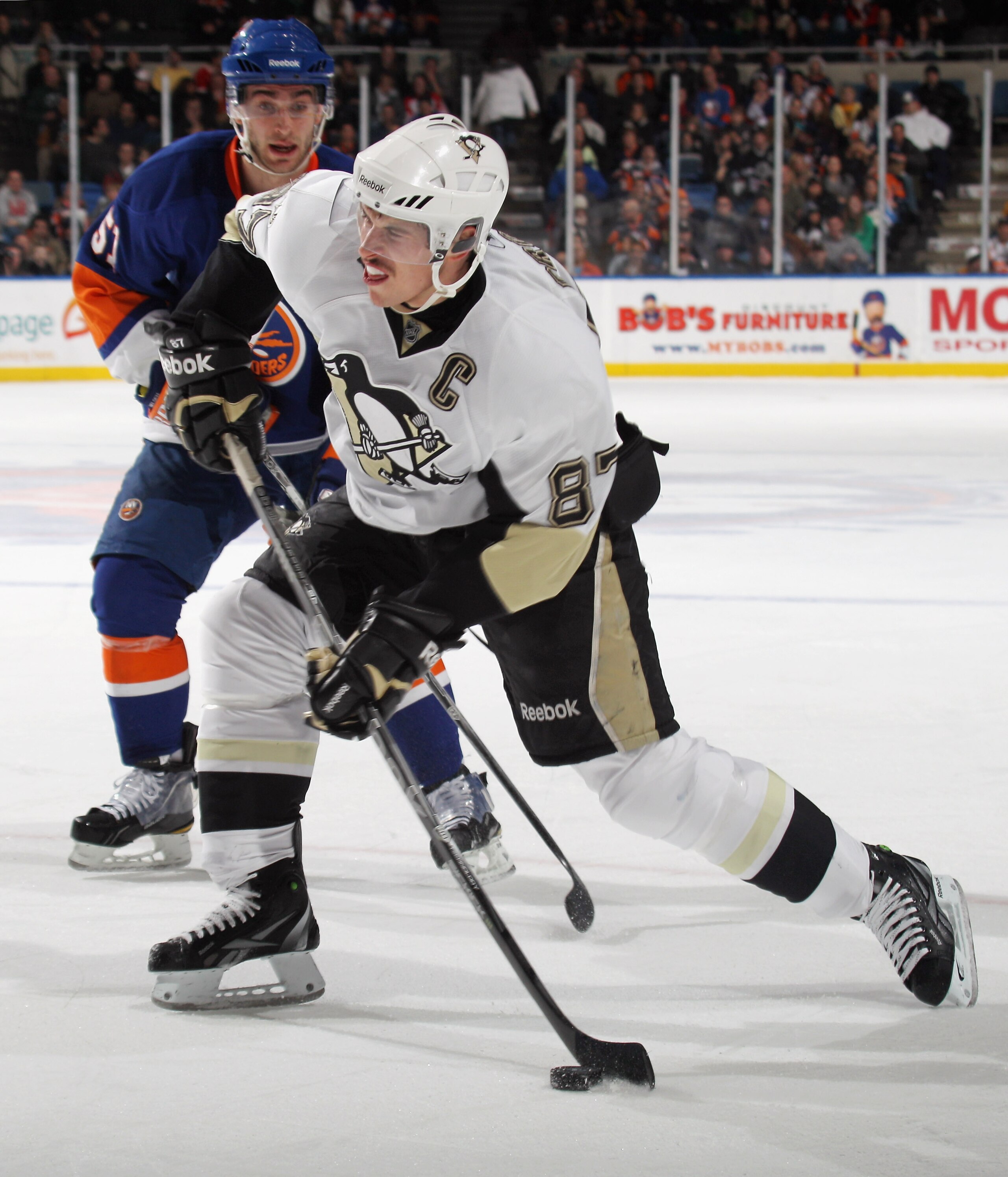 UNIONDALE, NY - DECEMBER 29: Sidney Crosby #87 of the Pittsburgh Penguins takes the shot against the New York Islanders at the Nassau Coliseum on December 29, 2010 in Uniondale, New York.  (Photo by Bruce Bennett/Getty Images)