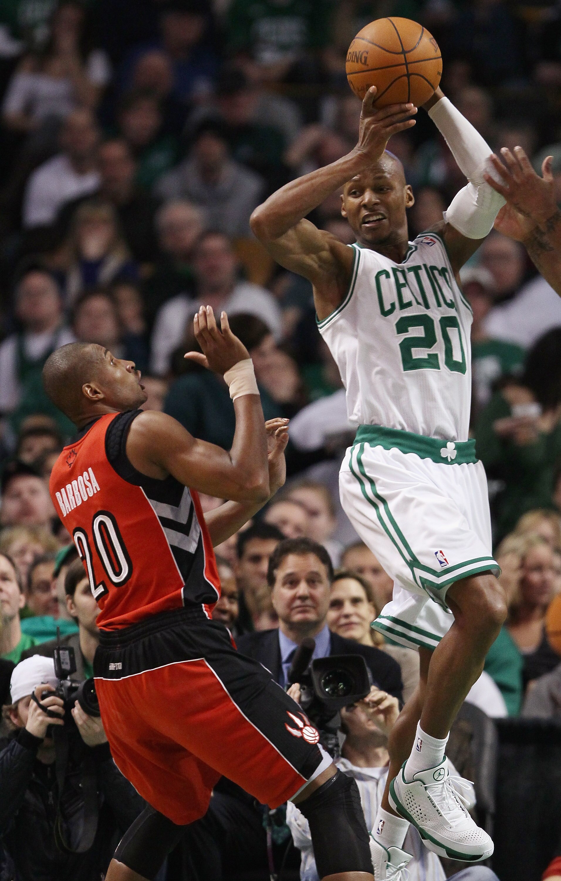 BOSTON, MA - JANUARY 07:  Ray Allen #20 of the Boston Celtics passes the ball as Leandro Barbosa #20 of the Toronto Raptors defends on January 7, 2011 at the TD Garden in Boston, Massachusetts. The Celtics defeated the Raptors 122-102. NOTE TO USER: User
