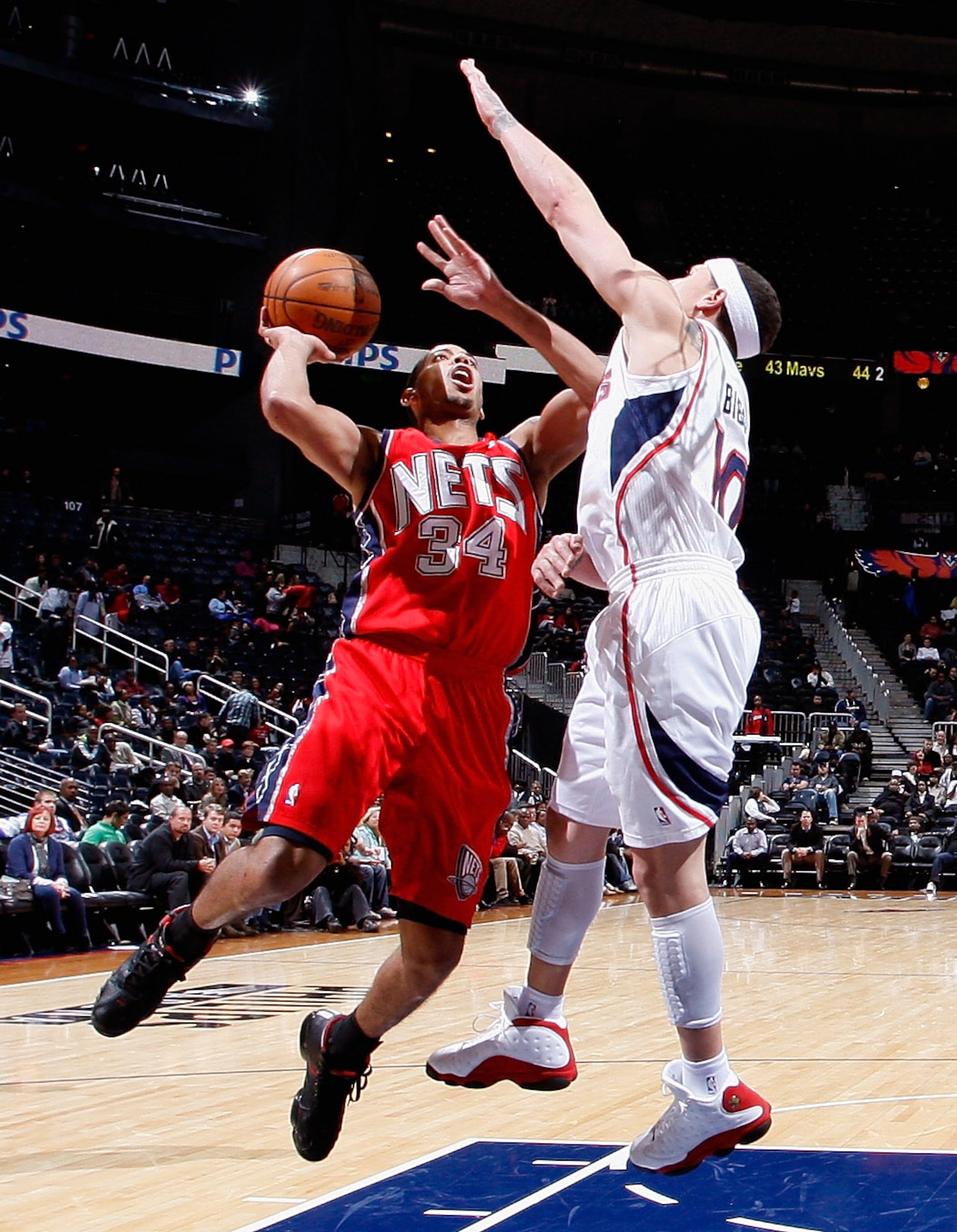 ATLANTA, GA - DECEMBER 07:  Devin Harris #34 of the New Jersey Nets drives against Mike Bibby #10 of the Atlanta Hawks at Philips Arena on December 7, 2010 in Atlanta, Georgia.  NOTE TO USER: User expressly acknowledges and agrees that, by downloading and