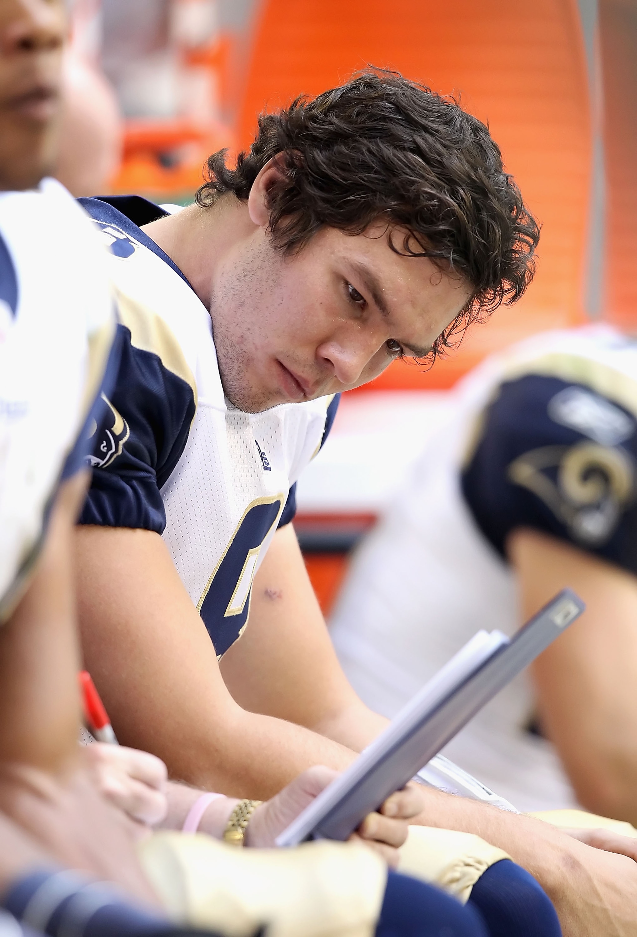 GLENDALE, AZ - DECEMBER 05:  Quarterback Sam Bradford #8 of the St. Louis Rams looks over plays on the sidelines during the NFL game against the Arizona Cardinals at the University of Phoenix Stadium on December 5, 2010 in Glendale, Arizona. The Rams defe
