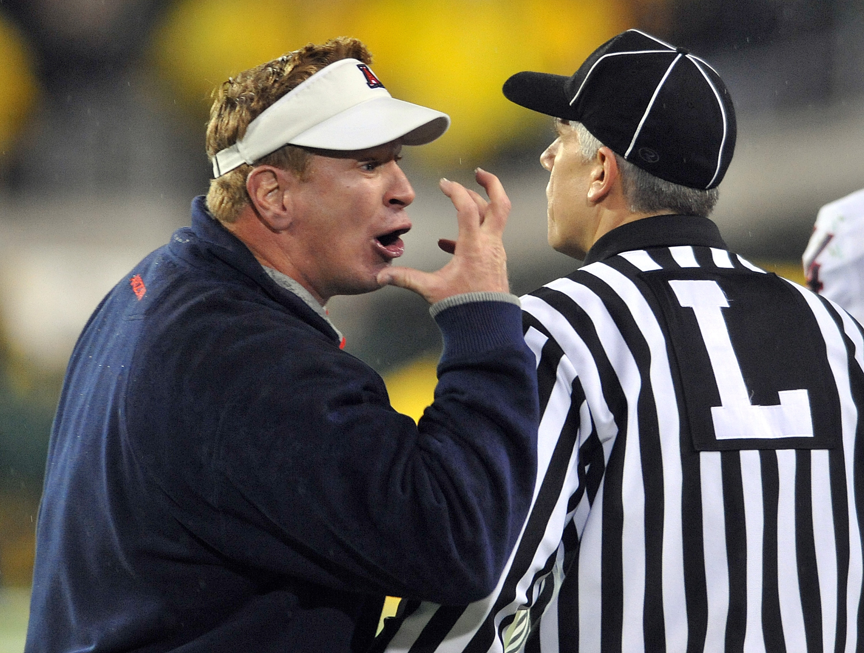 EUGENE, OR - NOVEMBER 26: Head coach Mike Stoops of the Arizona Wildcats has some words with head linesman Cappy Anderson in the second quarter of the game against the Oregon Ducks at Autzen Stadium on November 26, 2010 in Eugene, Oregon.The Ducks won the