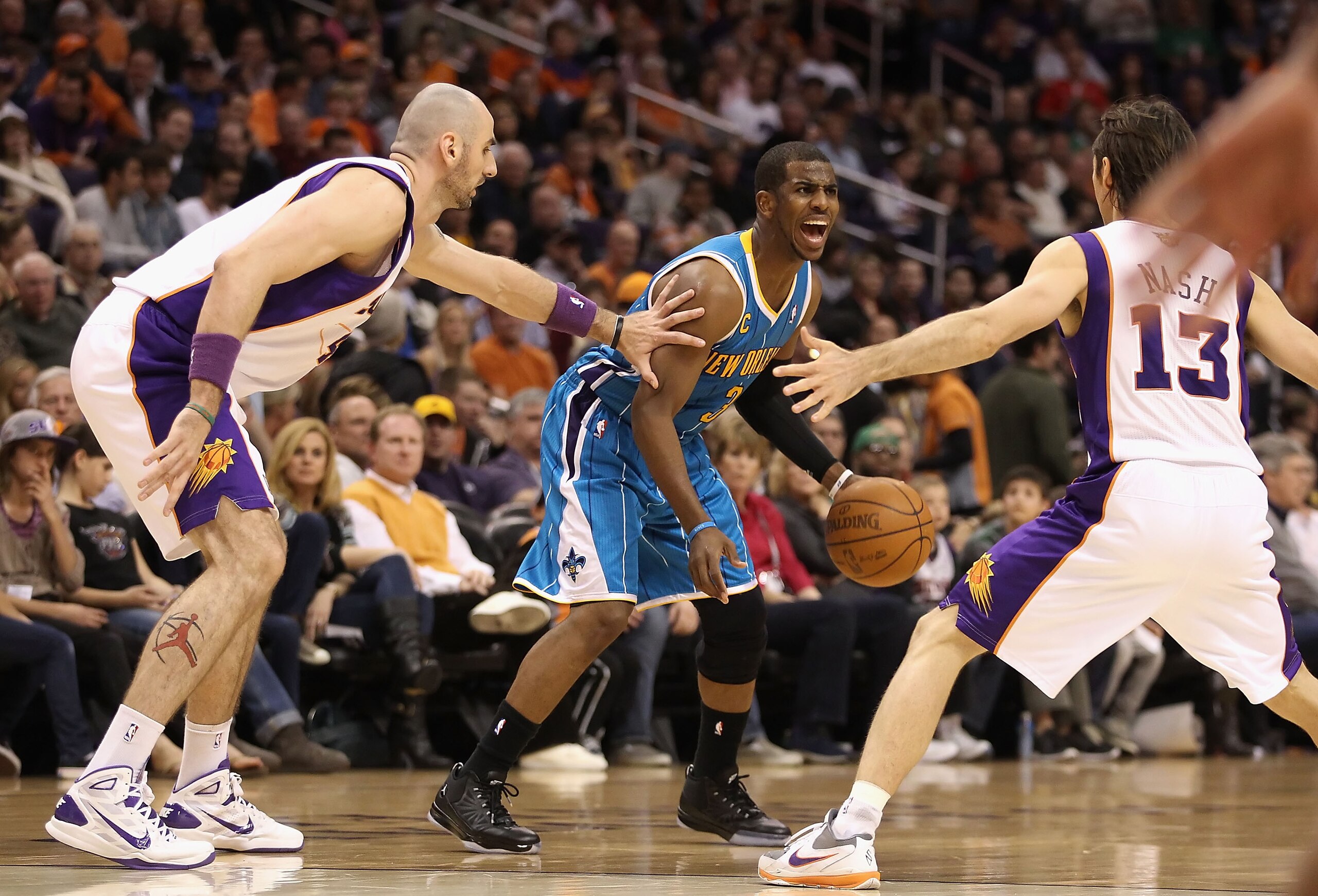 PHOENIX, AZ - JANUARY 30:  Chris Paul #3 of the New Orleans Hornets handles the ball guarded by Marcin Gortat #4 and Steve Nash #13 of the Phoenix Suns during the NBA game at US Airways Center on January 30, 2011 in Phoenix, Arizona.  The Suns defeated th