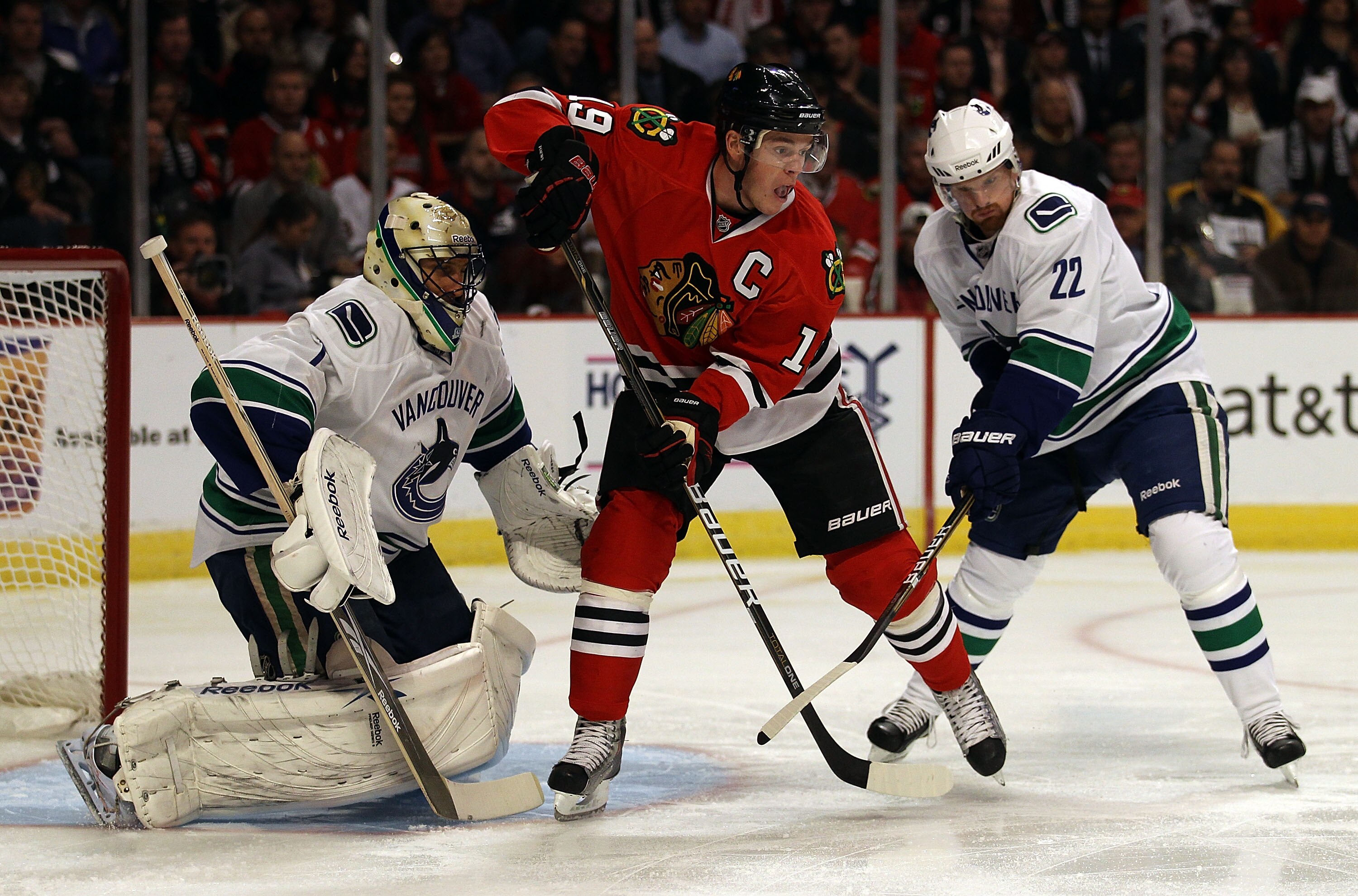 CHICAGO - OCTOBER 20: Jonathan Toews #19 of the Chicago Blackhawks awaits a pass between Roberto Luongo #1 (L) and Daniel Sedin #22 of the Vancouver Canucks at the United Center on October 20, 2010 in Chicago, Illinois. The Blackhawks defeated the Canucks