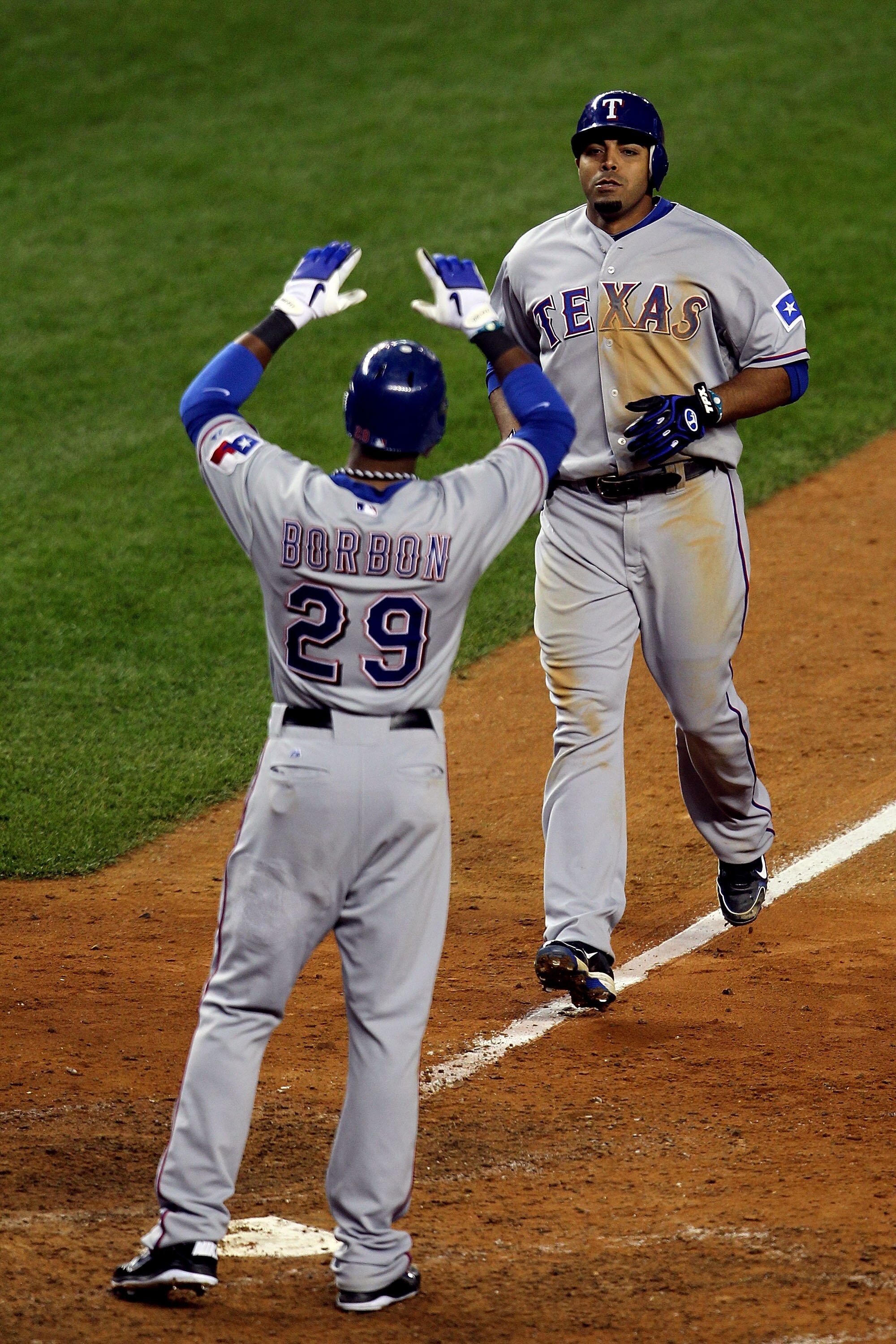 NEW YORK - OCTOBER 19:  Nelson Cruz #17 and Julio Borbon #29 of the Texas Rangers celebrate after they scored on Cruz's 2-run home run in the top of the ninth inning against the New York Yankees  in Game Four of the ALCS during the 2010 MLB Playoffs at Ya