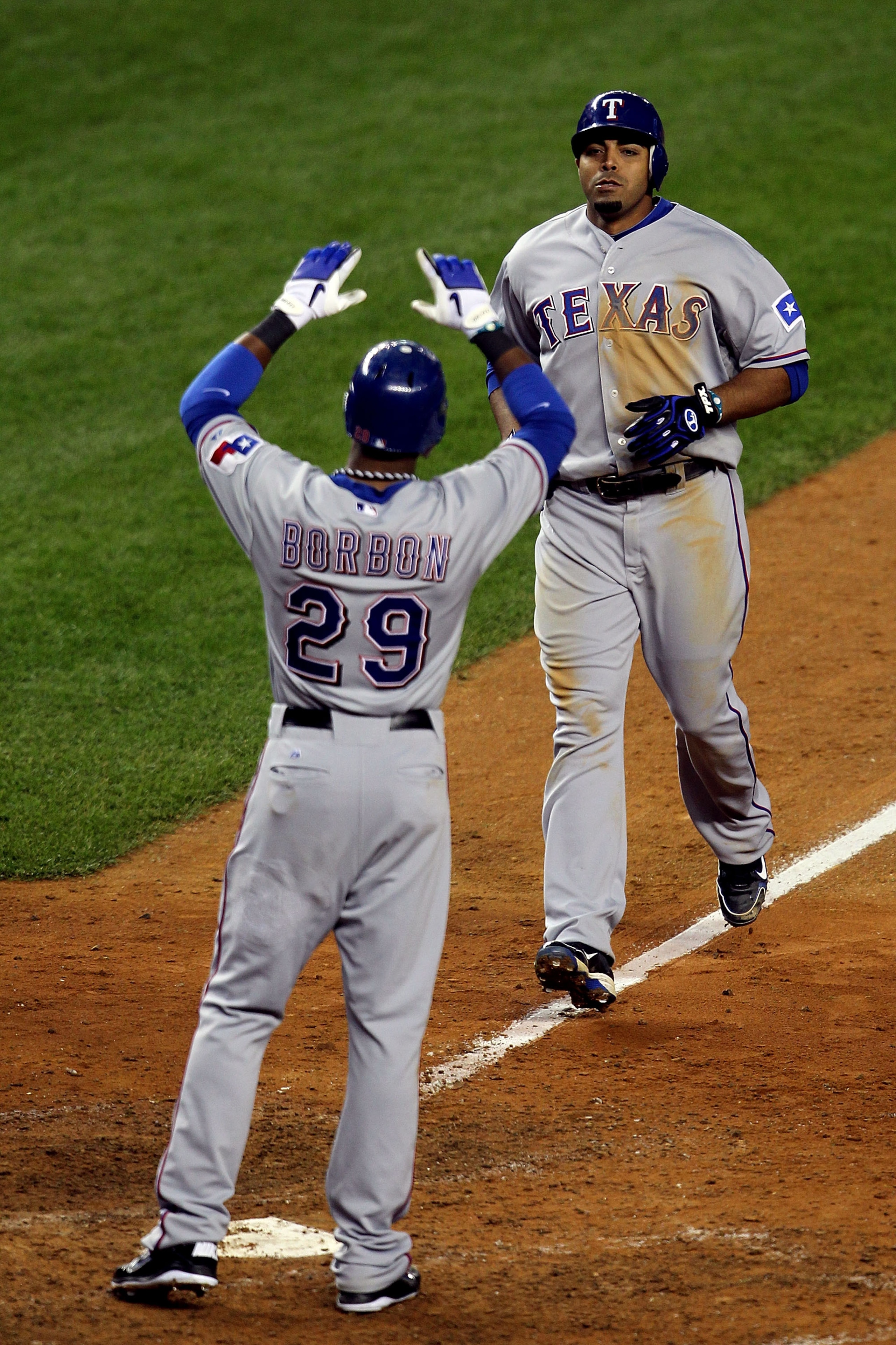 NEW YORK - OCTOBER 19:  Nelson Cruz #17 and Julio Borbon #29 of the Texas Rangers celebrate after they scored on Cruz's 2-run home run in the top of the ninth inning against the New York Yankees  in Game Four of the ALCS during the 2010 MLB Playoffs at Ya