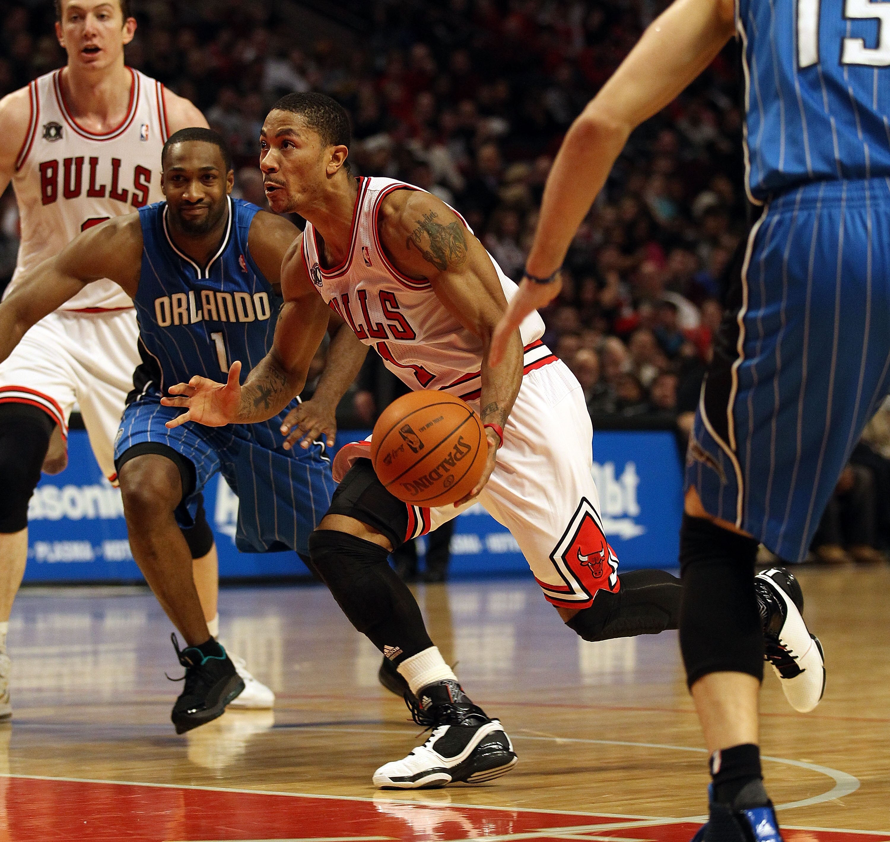 CHICAGO, IL - JANUARY 28: Derrick Rose #1 of the Chicago Bulls drives between Gilbert Arenas #1 and Hedo Turkoglu #15 of the Orlando Magic at the United Center on January 28, 2011 in Chicago, Illinois. The Bulls defeated the Magic 99-90. NOTE TO USER: Use